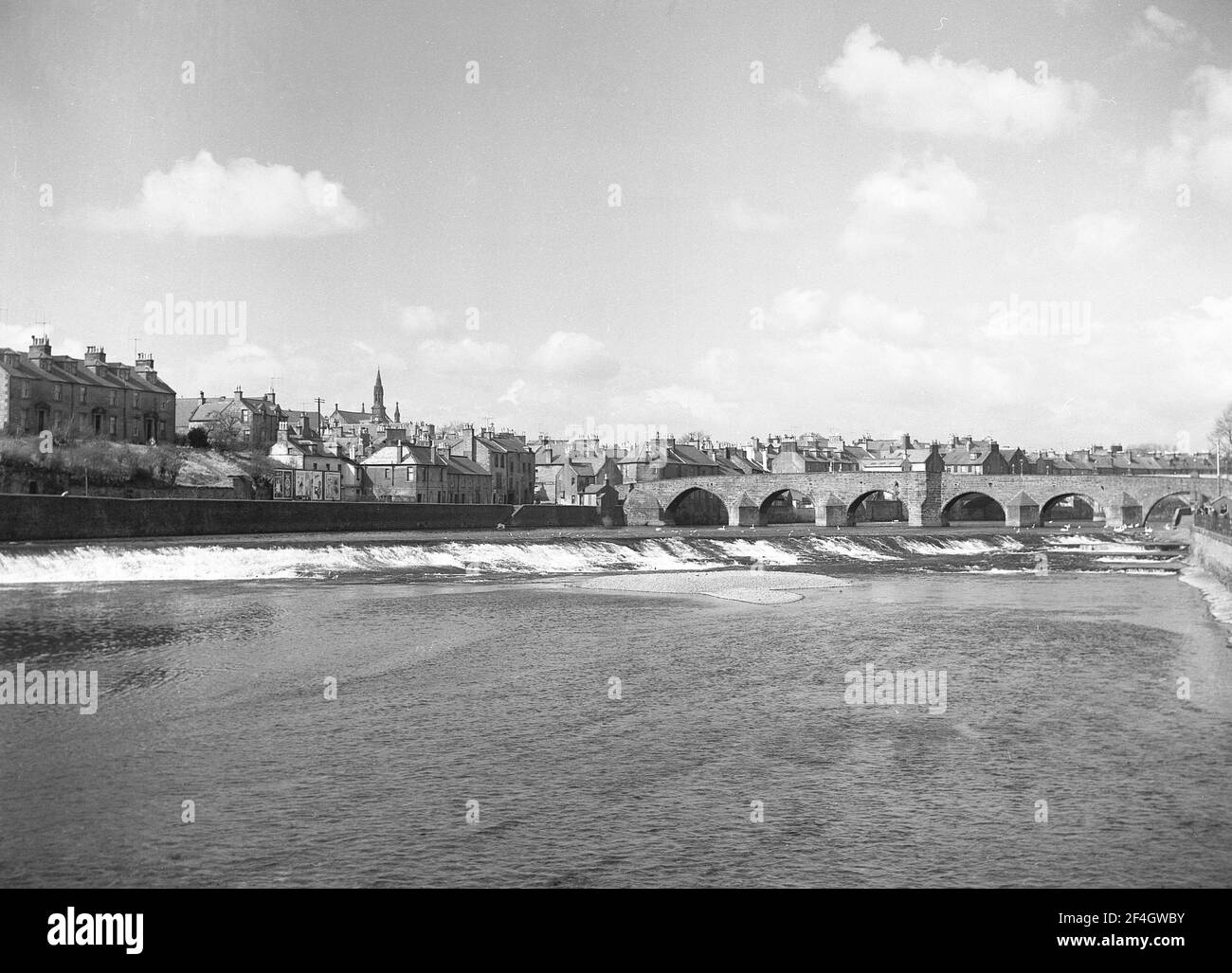 1951, historique, vue sur le fleuve Nith du pont Devorgilla, un ancien pont à Dumries, Écosse, Royaume-Uni. Également connu sous le nom de Devorgilla's Bridge, ce pont voûté de 6 travées est l'un des plus anciens ponts debout d'Écosse. Il avait à l'origine neuf arches, mais trois ont été emmenées en 1794 quand il a été reconstruit. Banque D'Images