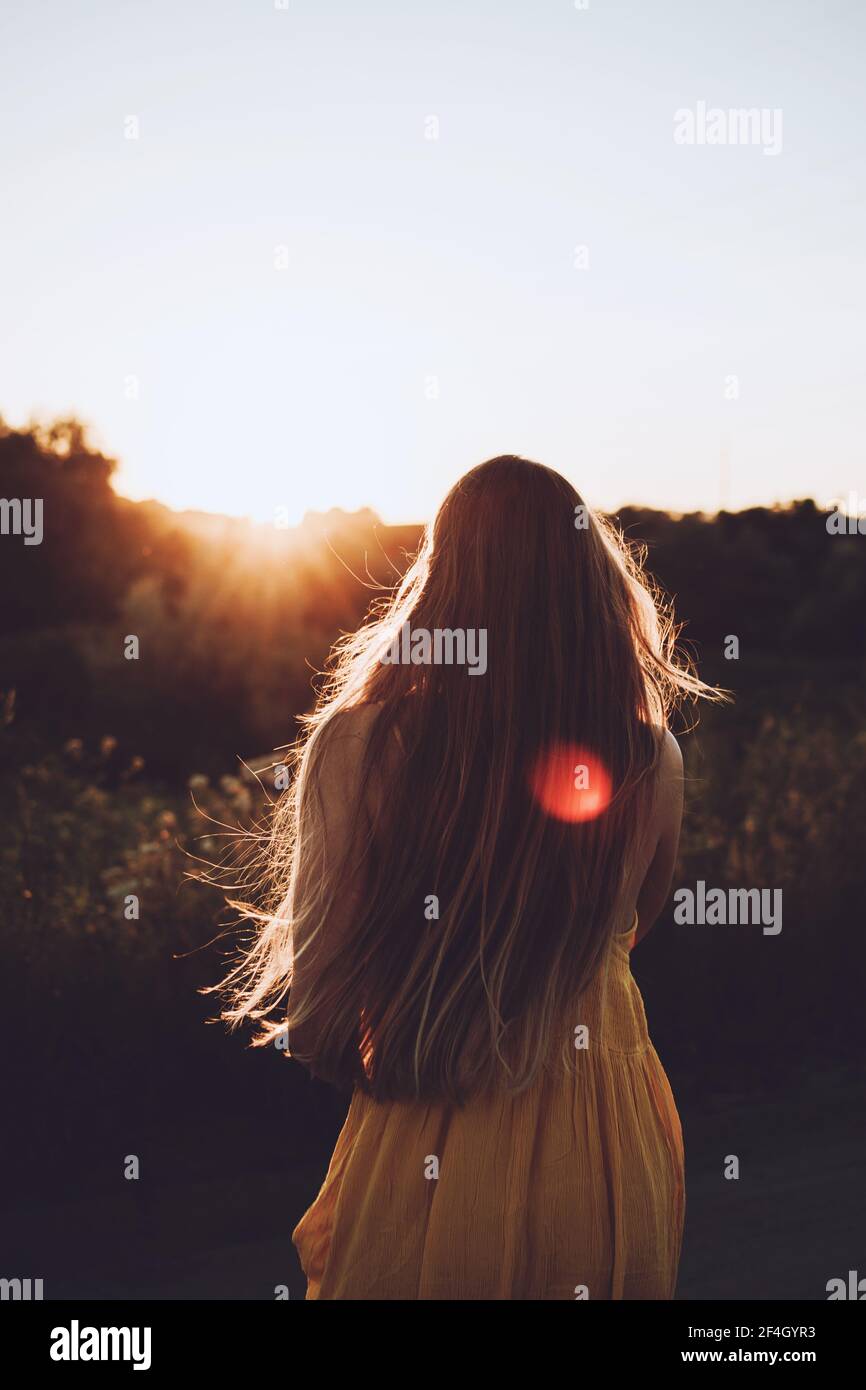 Pleine conscience, esprit positif, vivre dans le moment présent, vie lente. Portrait extérieur de la jeune femme blonde heureuse avec de longs cheveux de vent au coucher du soleil d'été Banque D'Images