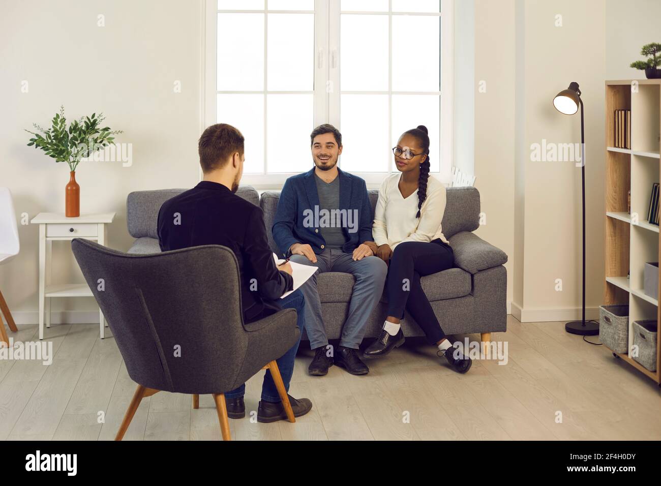 Heureux couple de race mixte rencontre psychiatre de famille ou conseiller financier Banque D'Images