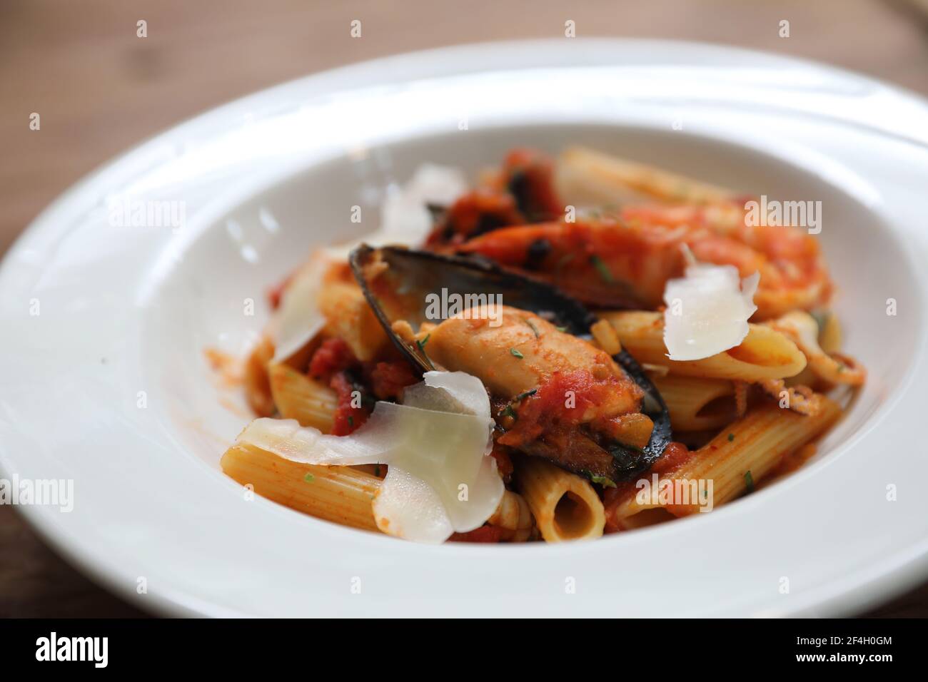 Penne sauce tomate arabiata avec fruits de mer sur fond de bois style vintage Banque D'Images