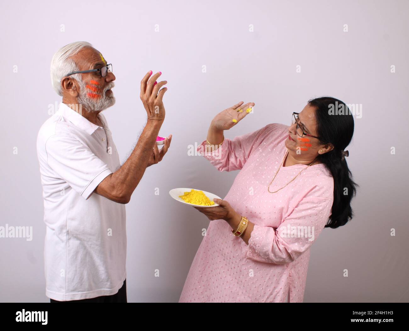 couple âgé d'âge ou d'âge indien célébrant le holi avec de la couleur Banque D'Images