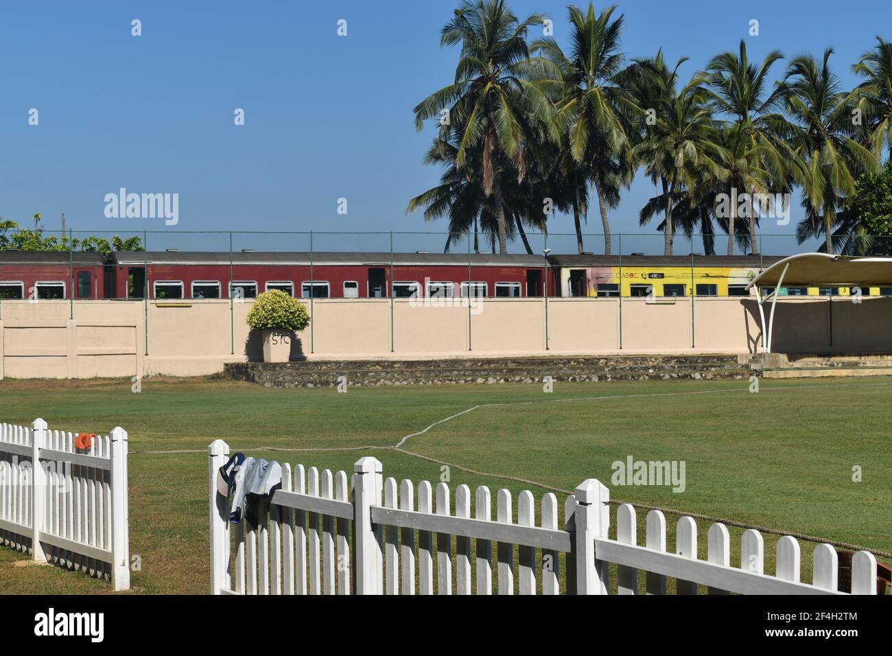 Le train passe près du terrain de cricket de l'école picturistique. St. Thomas College, Mt. Lavinia. Colombo, Sri Lanka. Banque D'Images