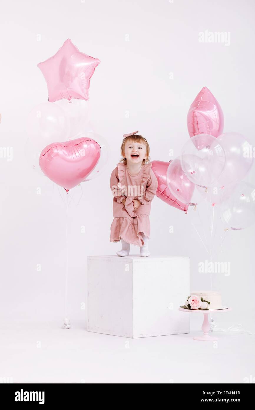 Joyeux Anniversaire 2 Ans Petite Fille En Robe Rose Gateau Blanc Avec Bougies Et Roses Decorations D Anniversaire Avec Ballons Blancs Et Roses Et Photo Stock Alamy