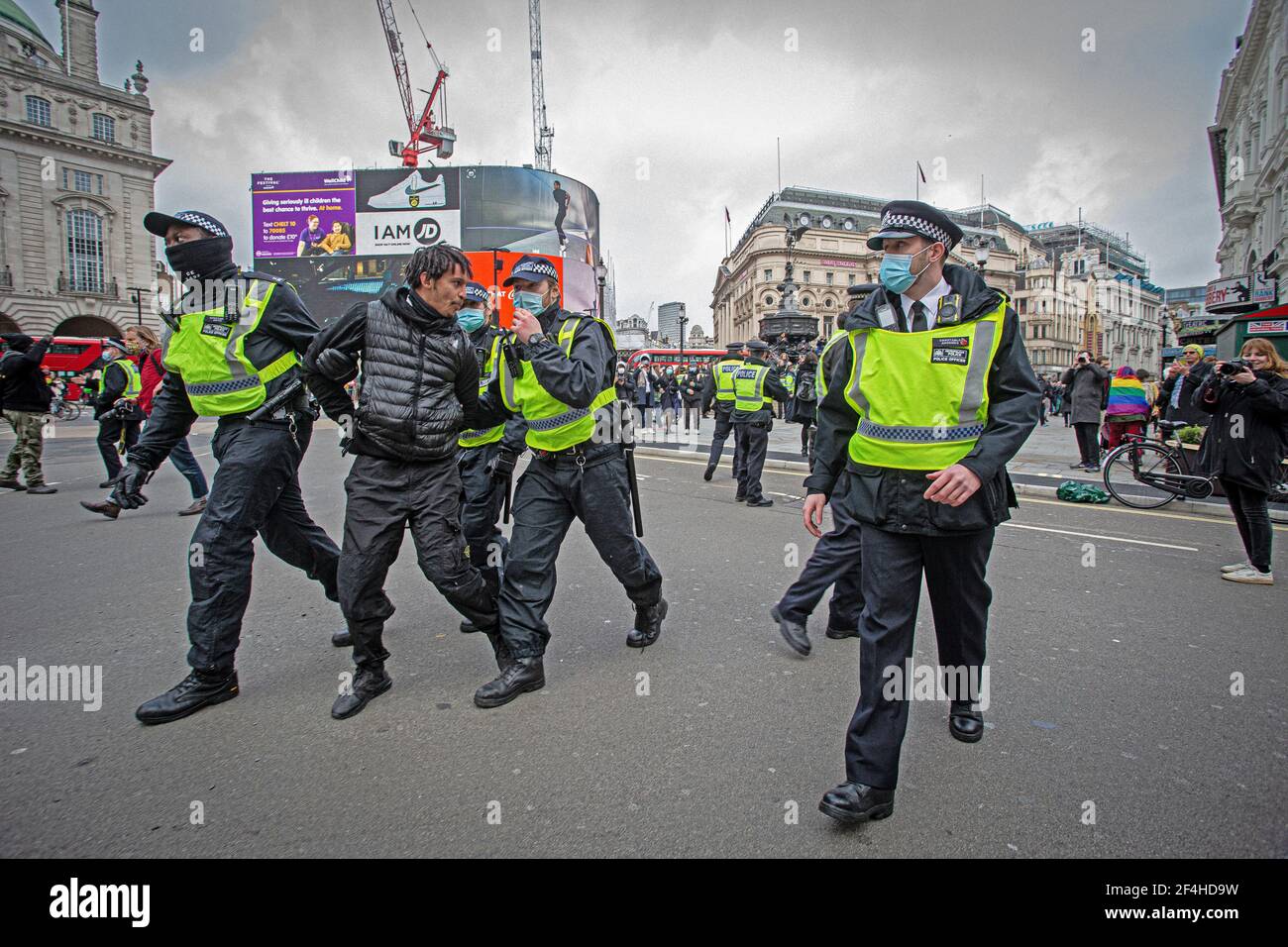 Londres, Royaume-Uni. 20 mars 2021. Un manifestant est détenu par la police MET pour avoir enfreint la loi nationale sur le confinement au cours de la manifestation.des milliers de rp Banque D'Images