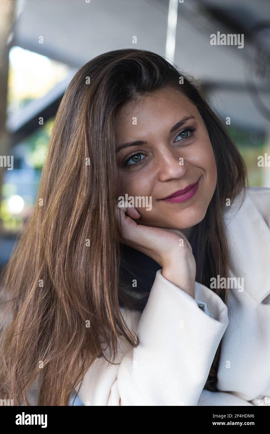 Bonne femme élégante, longue et souriante, qui regarde loin repos dans un café Banque D'Images