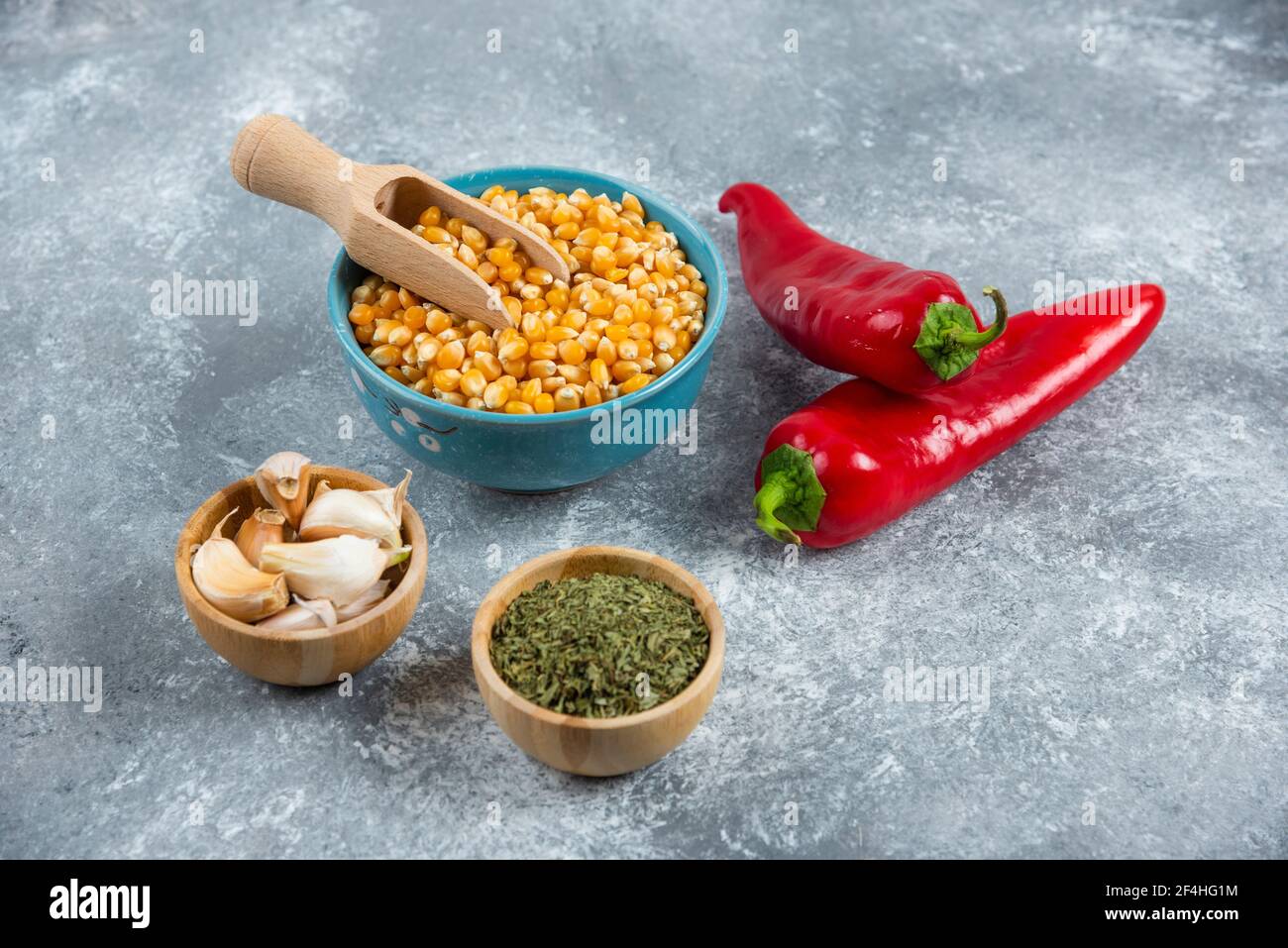 Bol de cornes crues, ail et piment rouge sur fond de marbre Banque D'Images