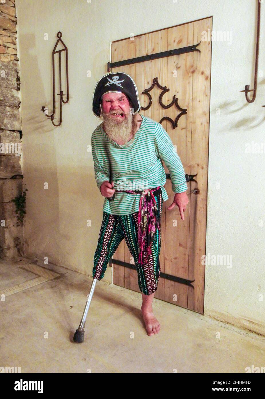 Homme barbu plus âgé manquant la jambe droite inférieure en utilisant son handicap pour s'habiller comme un pirate. Banque D'Images