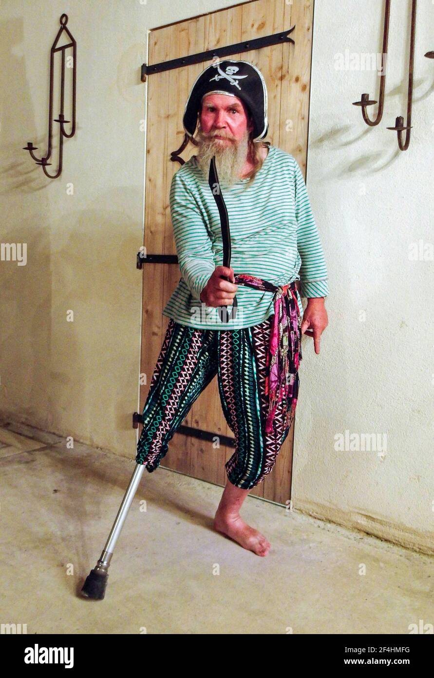 Homme barbu plus âgé manquant la jambe droite inférieure en utilisant son handicap pour s'habiller comme un pirate. Banque D'Images