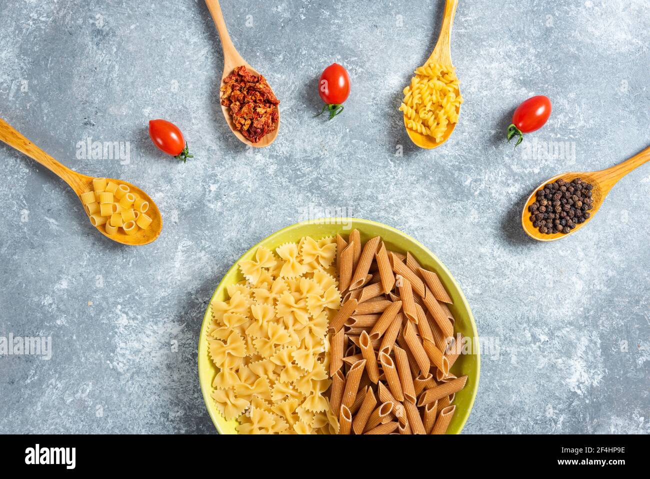 Deux sortes de pâtes crues sur l'assiette avec différentes épices Banque D'Images