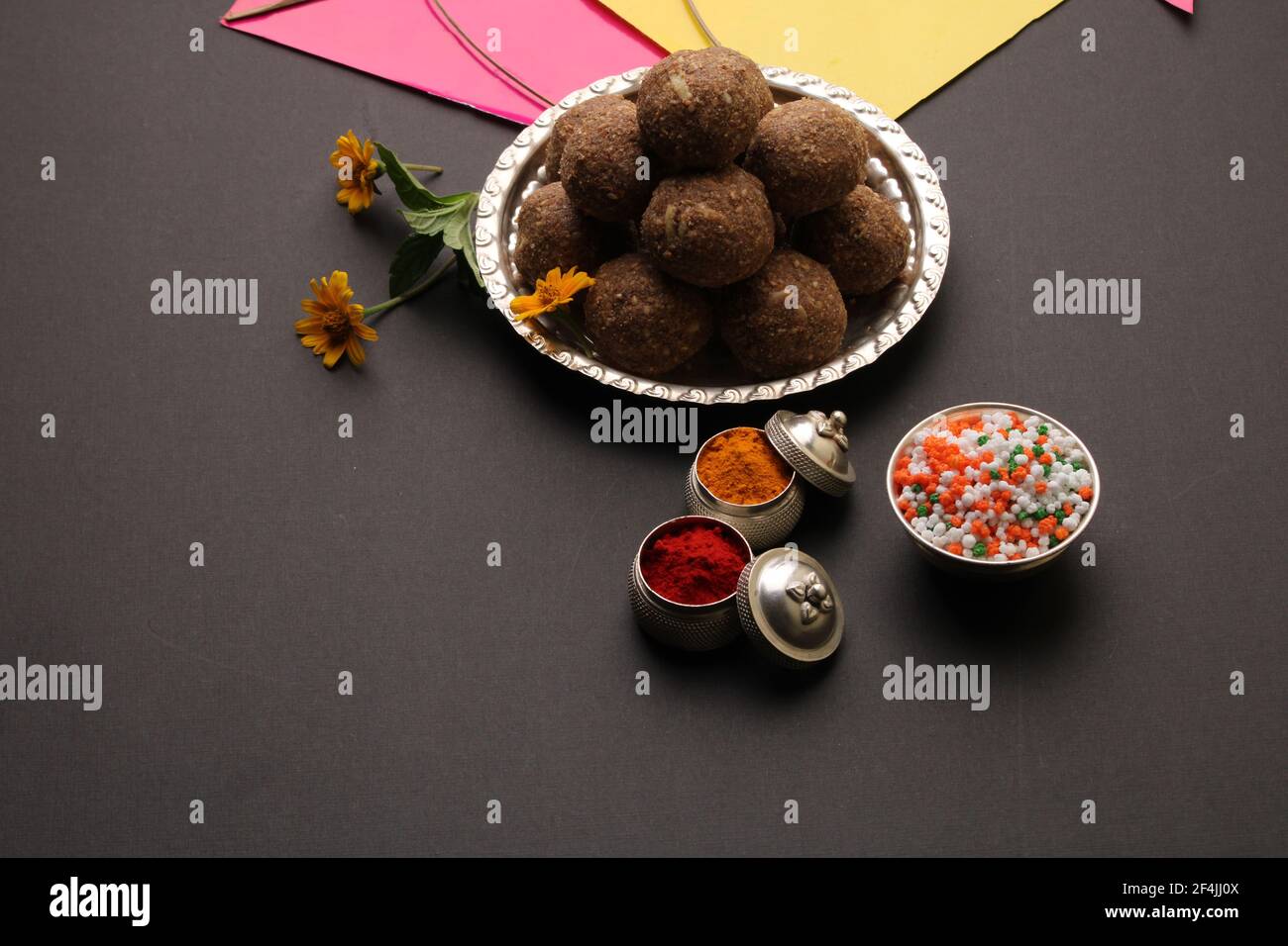 Til Gul OU Sweet Sesame Laddu avec Kite model, haldi Kumkum et cristaux de sucre pour le festival Makar Sankranti sur fond noir. Banque D'Images