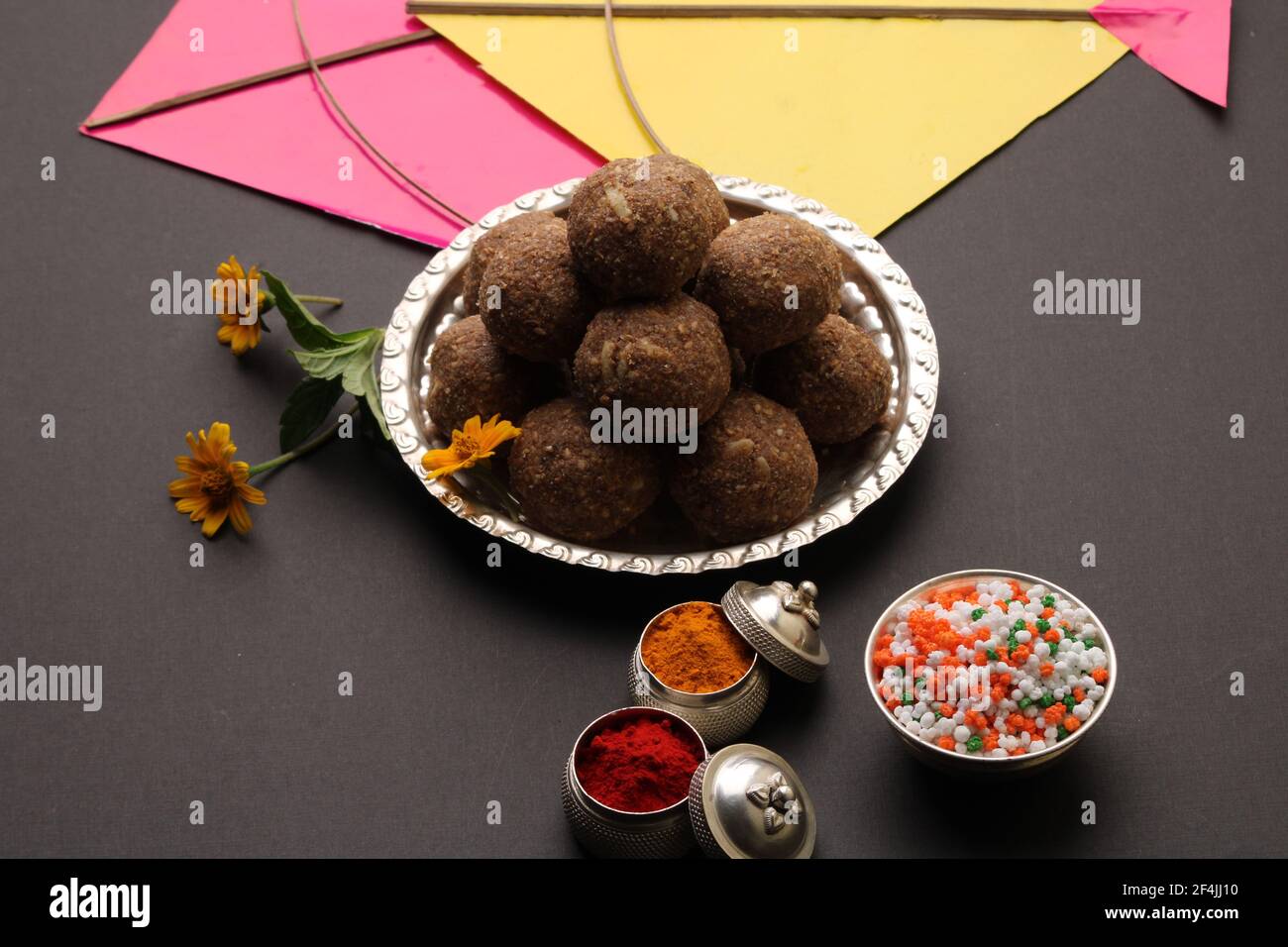 Til Gul OU Sweet Sesame Laddu avec Kite model, haldi Kumkum et cristaux de sucre pour le festival Makar Sankranti sur fond noir. Banque D'Images