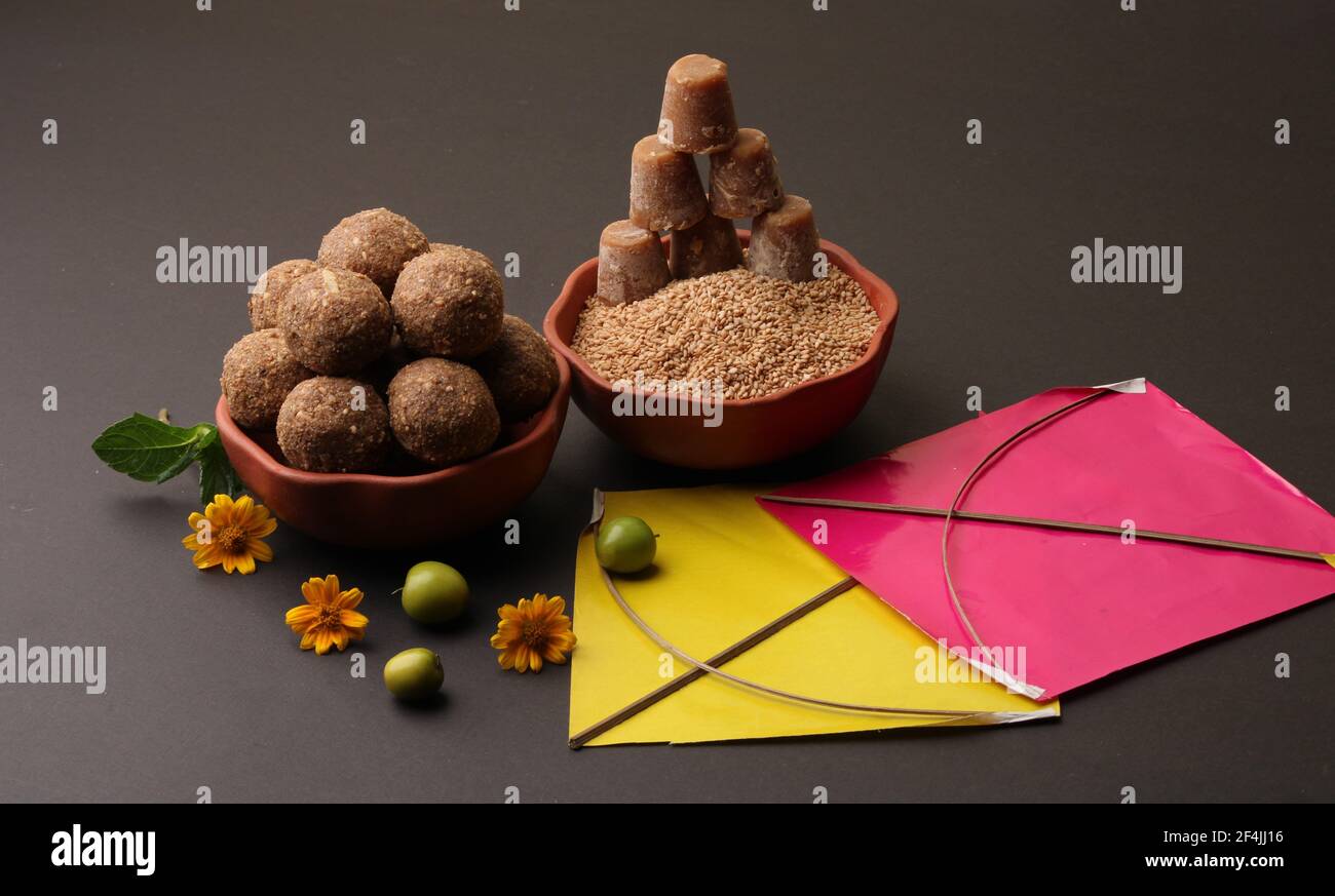 Til Gul OU Sweet Sesame Laddu avec Kite model, haldi Kumkum et cristaux de sucre pour le festival Makar Sankranti sur fond noir. Banque D'Images