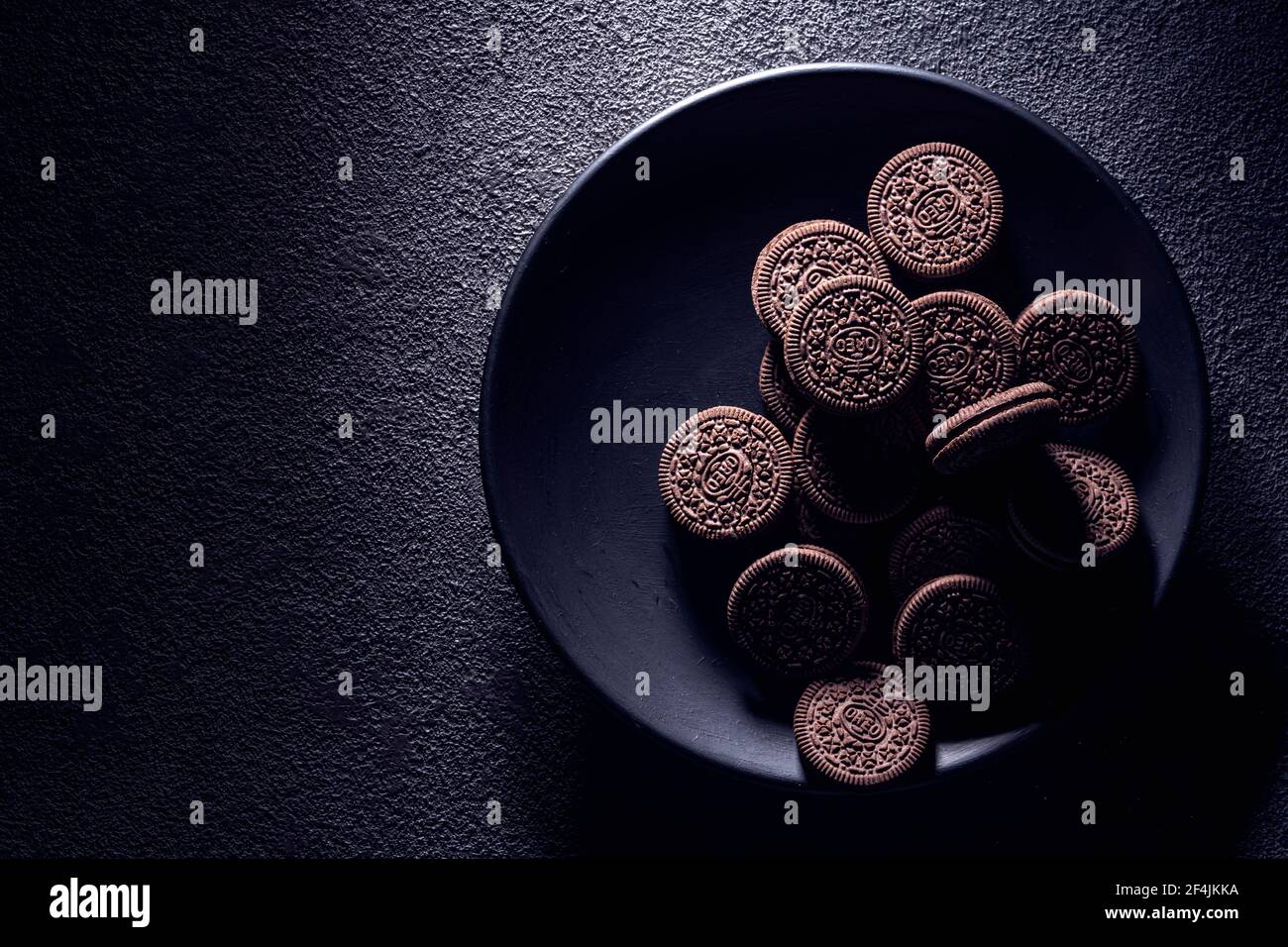 KRASNOYARSK, RUSSIE, 9 février 2020 : biscuits oreiro noirs en gros plan dans une assiette, vue du dessus. Arrière-plan texturé sombre. Banque D'Images