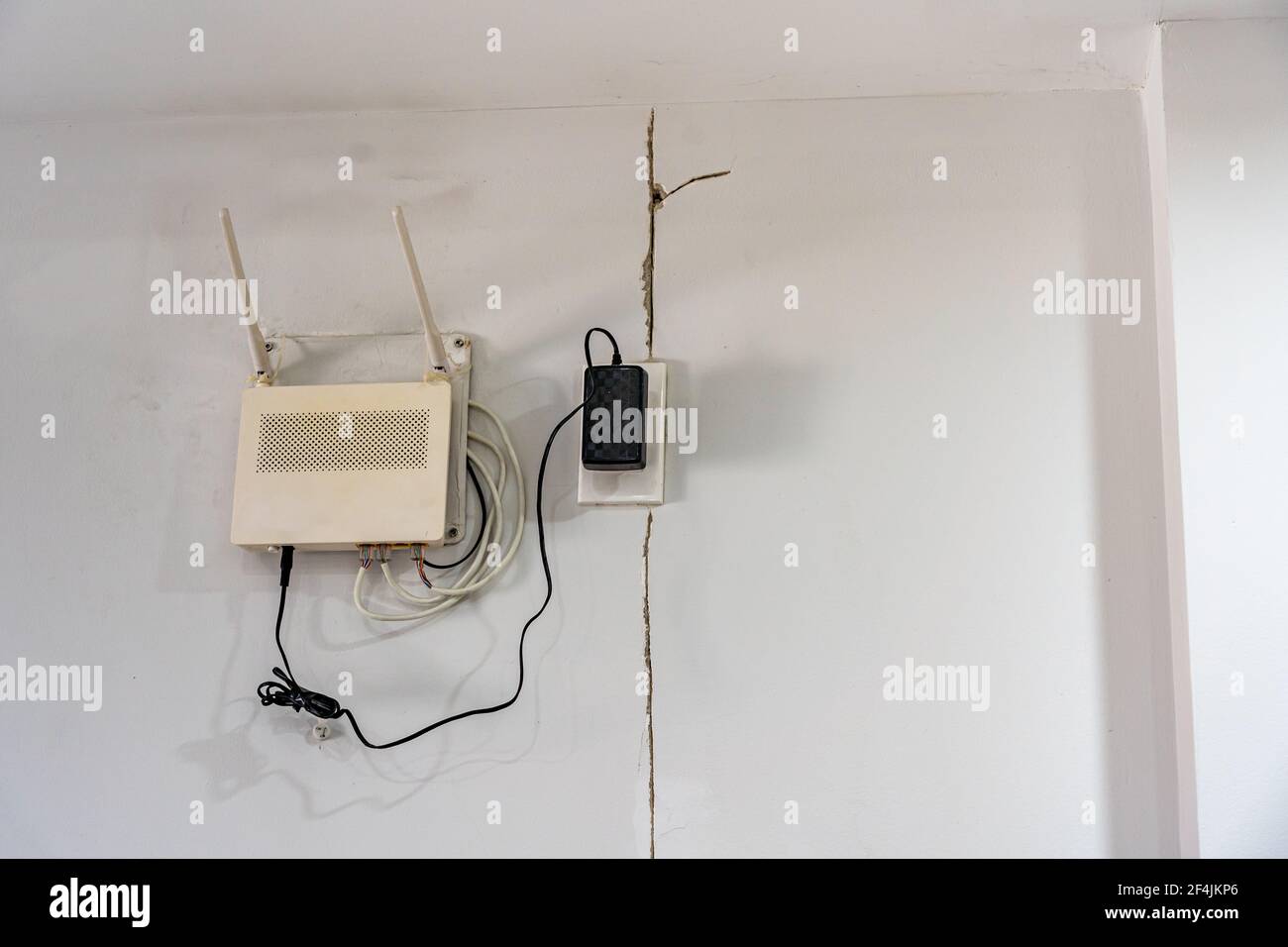 Texture fissure sévère sur le mur blanc près du wi-fi zone du modem Banque D'Images