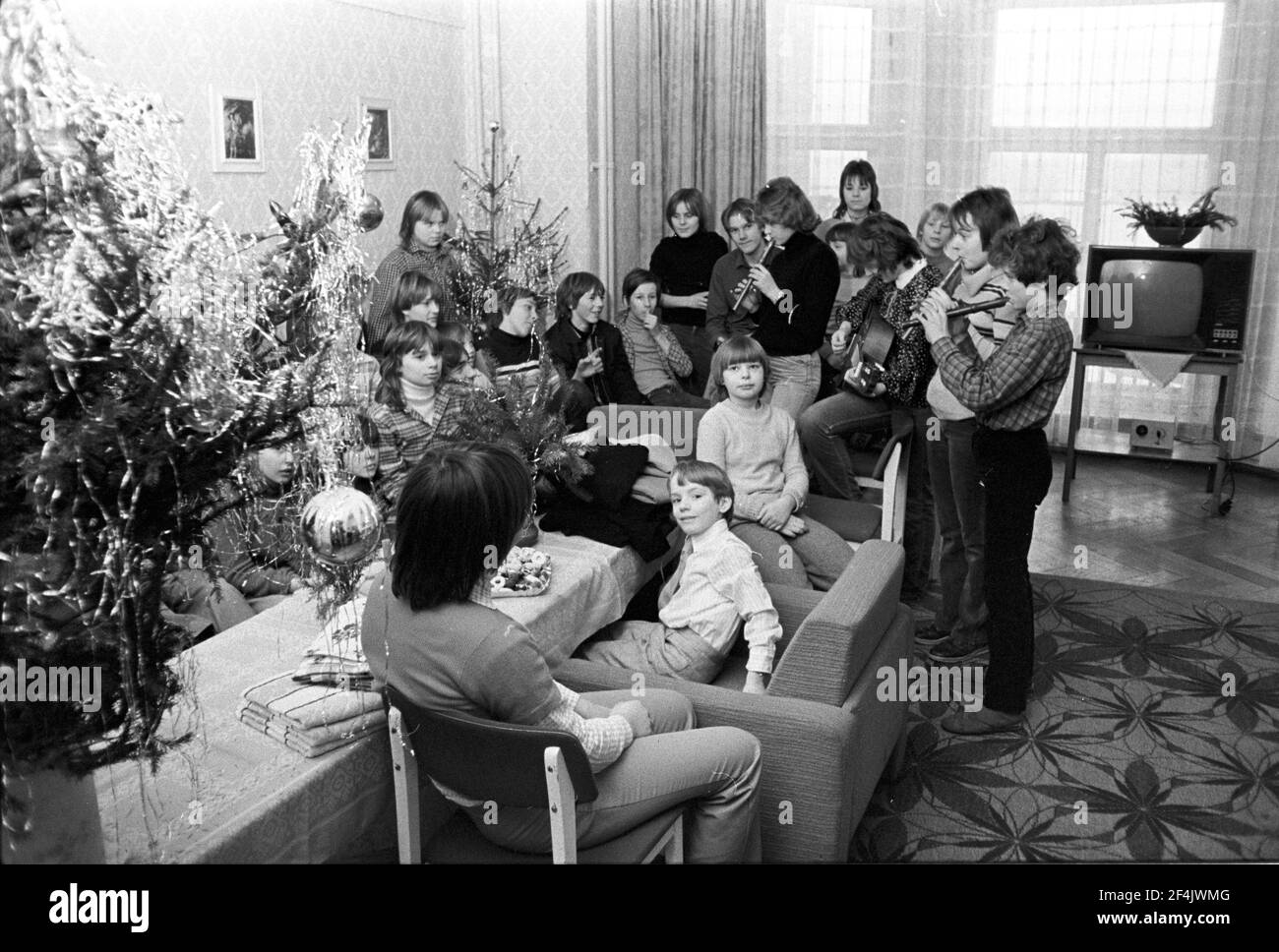 25 décembre 1981, Saxe, Delitzsch: Concert avec flûtes et guitare. Les enfants dans une maison d'enfants dans le quartier de Delitzsch fêtent Noël fin 1981. Date exacte de l'enregistrement inconnue. Photo: Volkmar Heinz/dpa-Zentralbild/ZB Banque D'Images