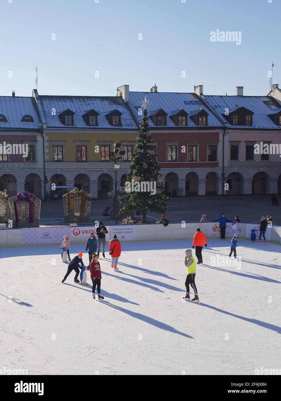Zamosc, Pologne, 27 décembre 2020. Les habitants de la ville patinent sur une patinoire le matin d'hiver ensoleillé. Patinoire sur la place centrale de la ville. Banque D'Images