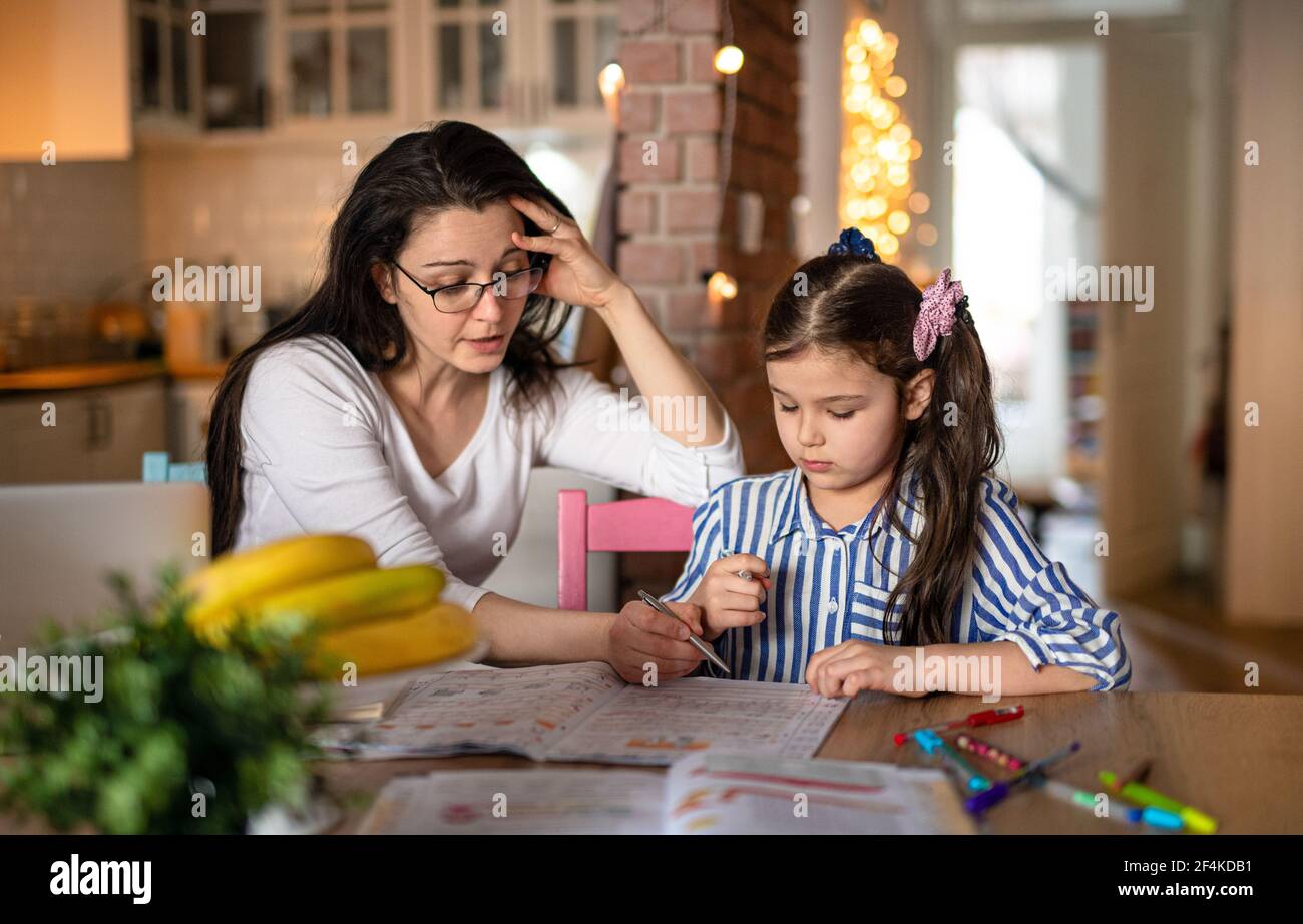 Mère avec petite fille dans la cuisine, école à domicile et concept d'apprentissage à distance. Banque D'Images