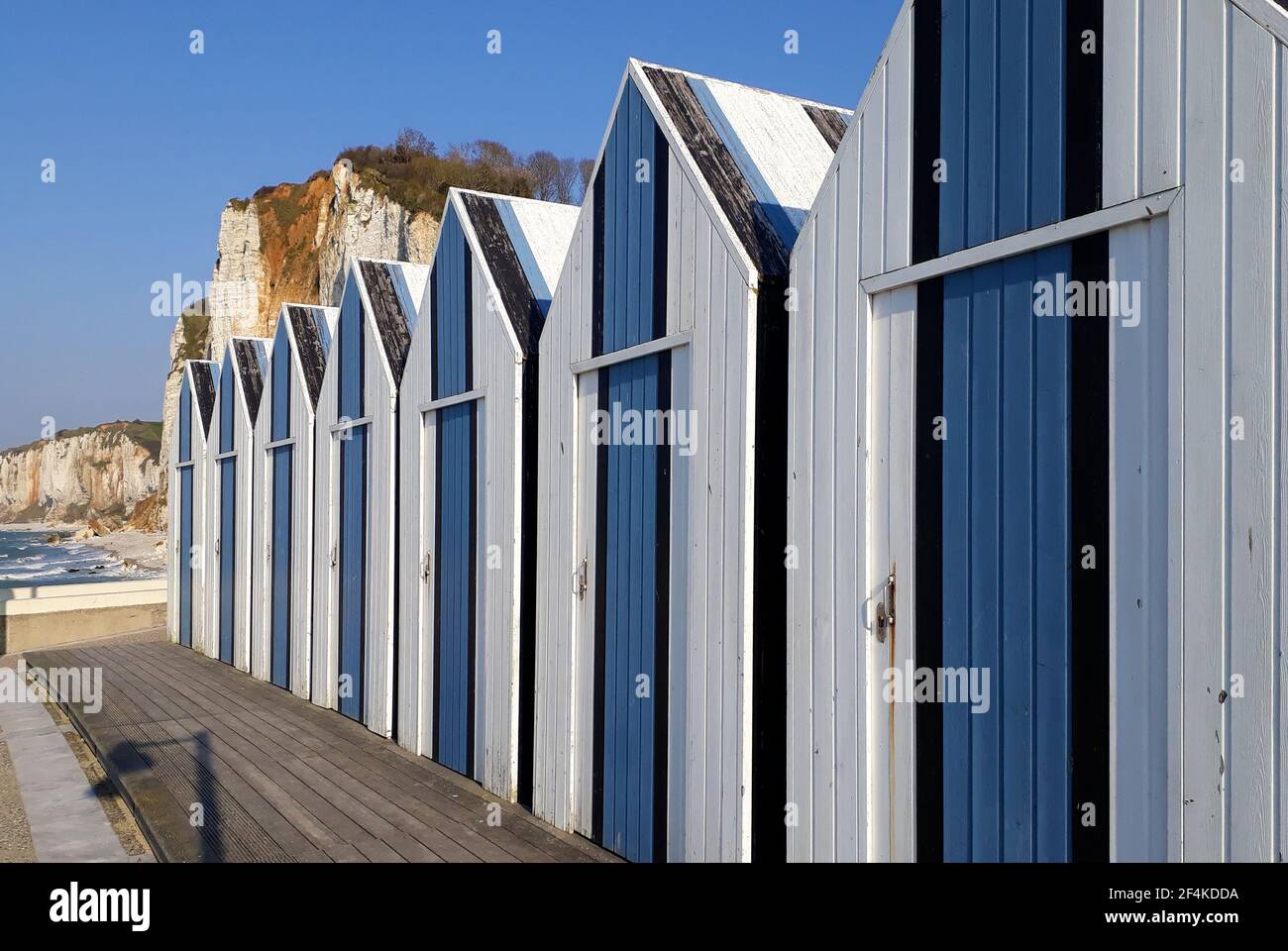 Vacances à Yport avec des cabanes de pêcheurs bleues et blanches la plage et les falaises en arrière-plan Banque D'Images