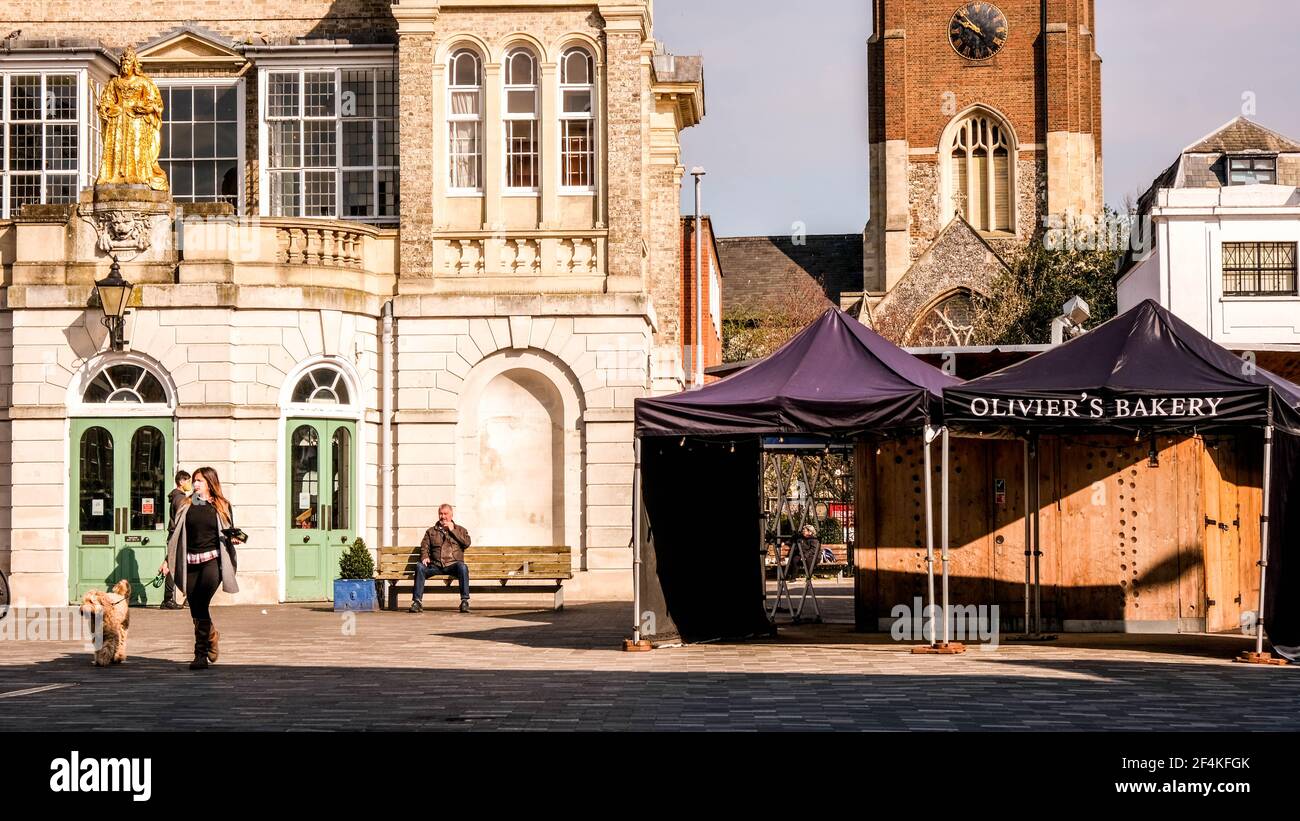 Londres Royaume-Uni, mars 22 2021, une femme marchant sur une place du marché vide seule avec son chien en tête Banque D'Images