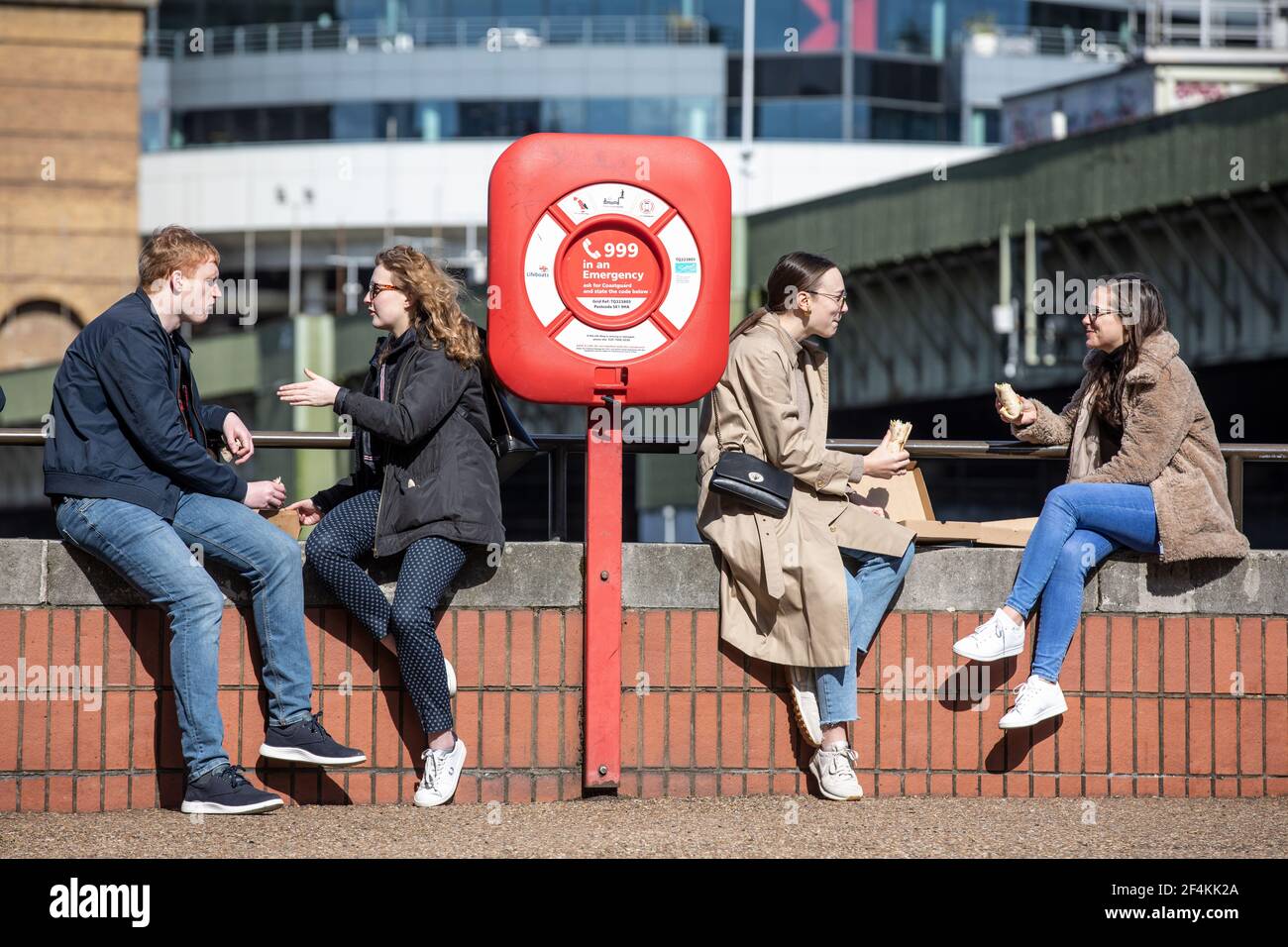 Les Londoner's s'assoient le long de la Tamise, sur la rive de Southwark, en profitant du soleil du début du printemps, à l'heure du déjeuner, en Angleterre, au Royaume-Uni Banque D'Images