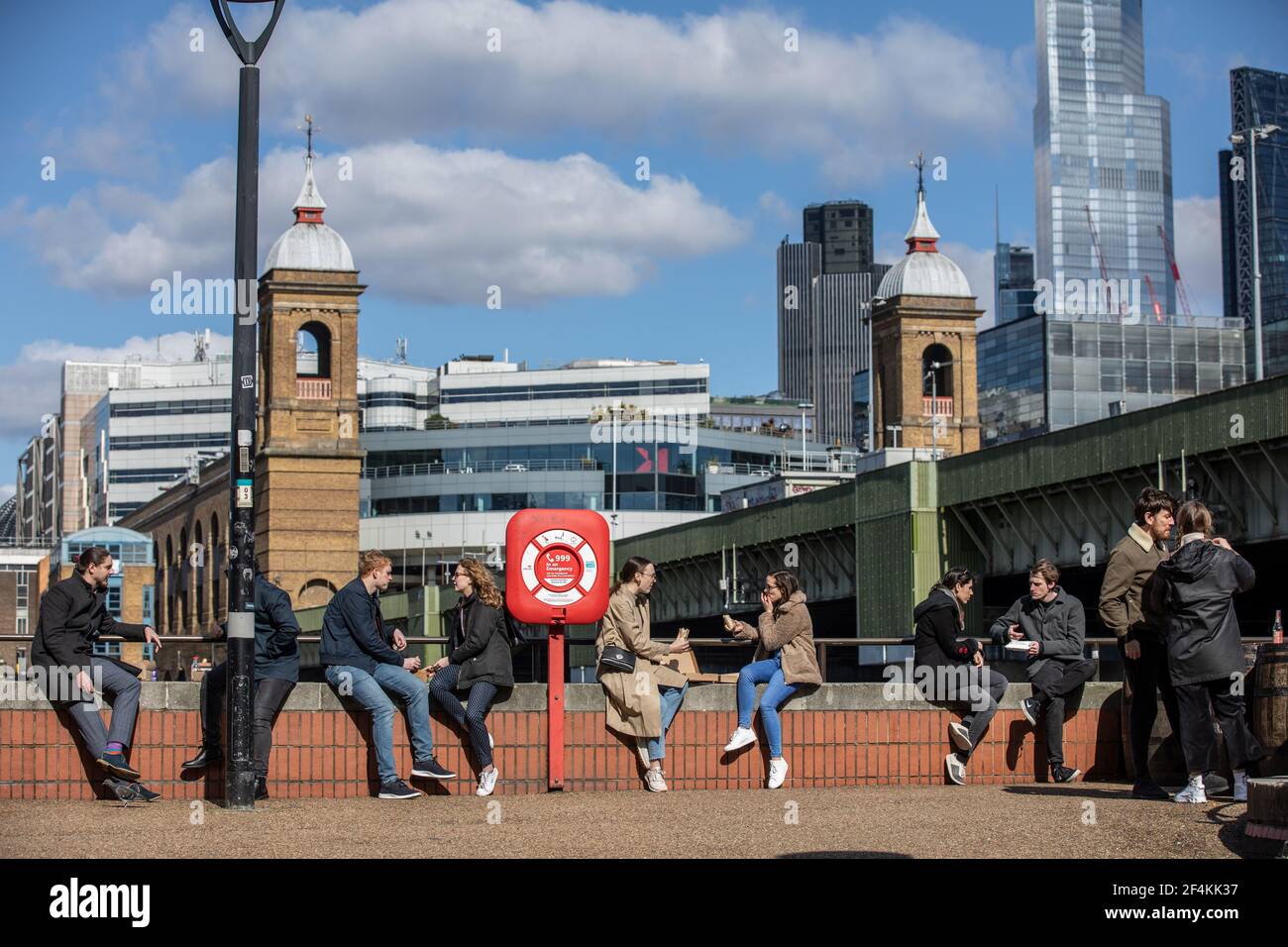 Les Londoner's s'assoient le long de la Tamise, sur la rive de Southwark, en profitant du soleil du début du printemps, à l'heure du déjeuner, en Angleterre, au Royaume-Uni Banque D'Images