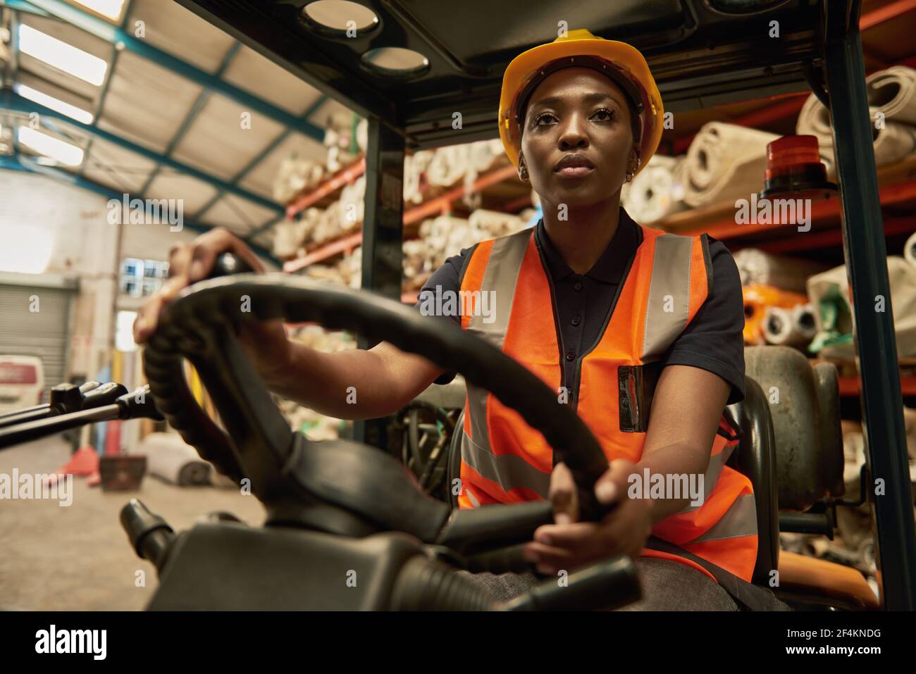 Opérateur de chariot élévateur féminin africain au travail dans un entrepôt textile Banque D'Images