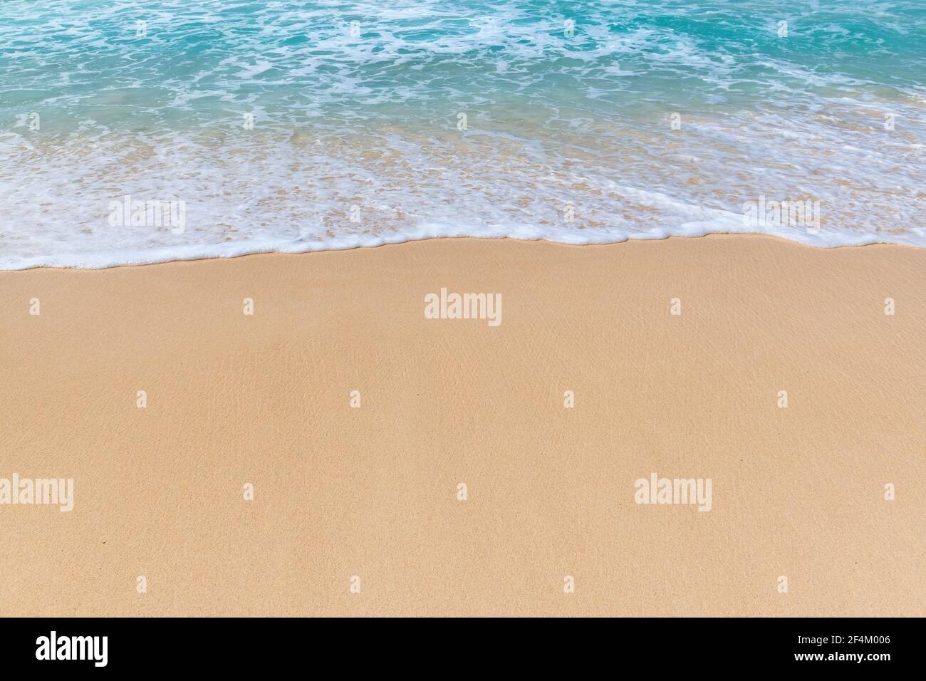 Vague bleue de la mer avec mousse blanche sur la plage de sable dans île tropicale Banque D'Images