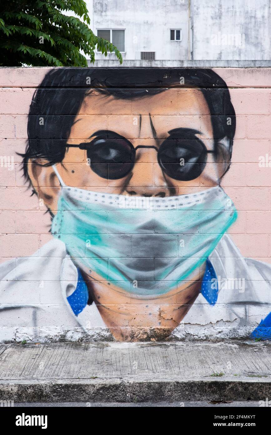 Peinture murale rue publique d'un homme portant des lunettes et un masque de covid19. Écran vertical Graffiti au Mexique Banque D'Images