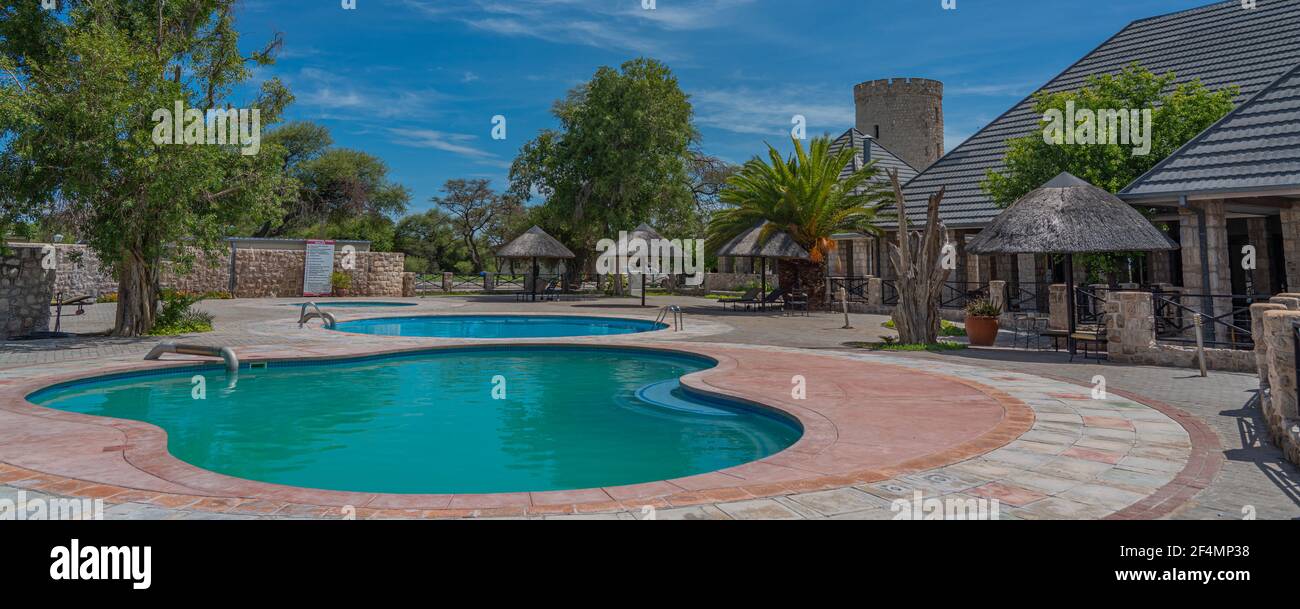 OKAUKUEJO, NAMIBIE - 14 JANVIER 2020 : complexe Okaukuejo avec toit de chaume et piscine dans le parc national d'Etosha Banque D'Images