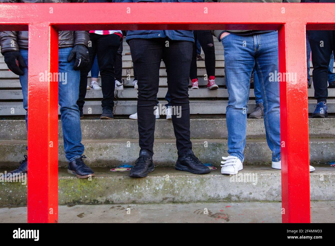Les fans et les spectateurs regardent le match de football de la ligue inférieure pendant Covid-19, pandémie du coronavirus en Angleterre, au Royaume-Uni. Porter des revêtements de visage et des masques de visage. Banque D'Images