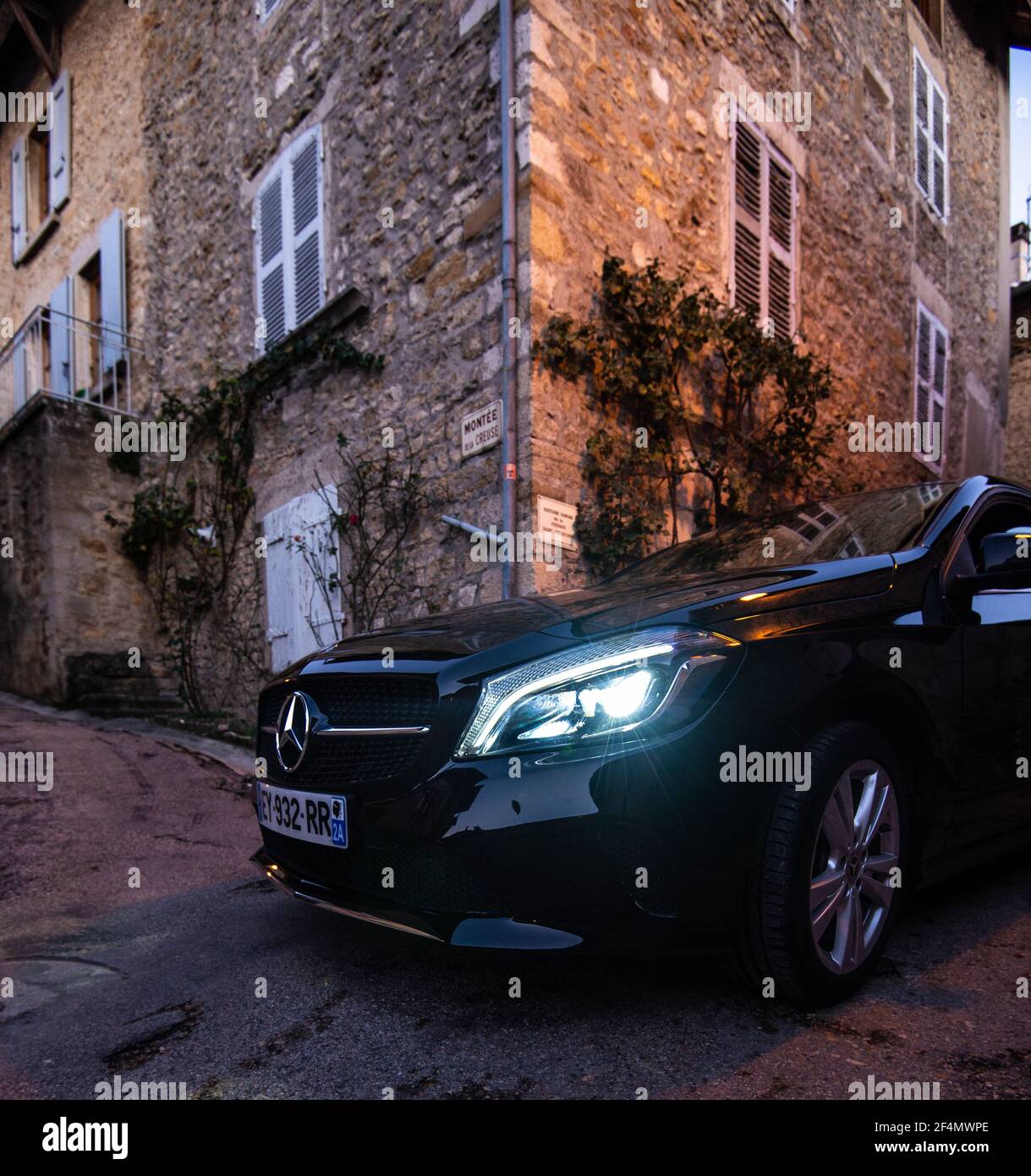 Mercedes Benz voiture de luxe dans les rues étroites de la ville de Lyon. Vue rapprochée d'une voiture noire haut de gamme dans les rues urbaines Banque D'Images