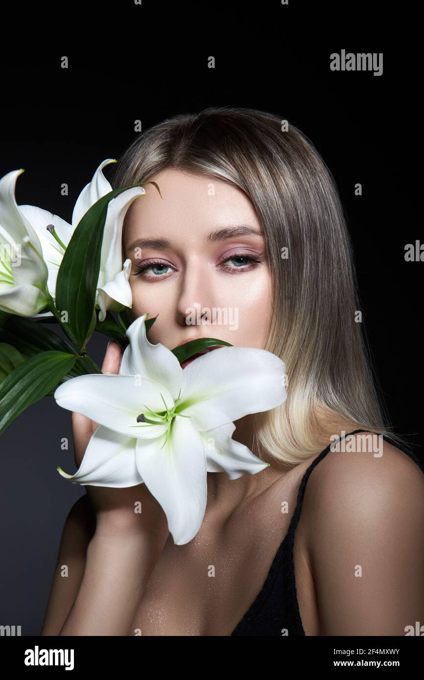 Femme couleur de cheveux d'une blonde avec fleur de nénuphars sur fond noir. Modèle de femme à colorier en couleur de frêne. Portrait d'une fille Banque D'Images
