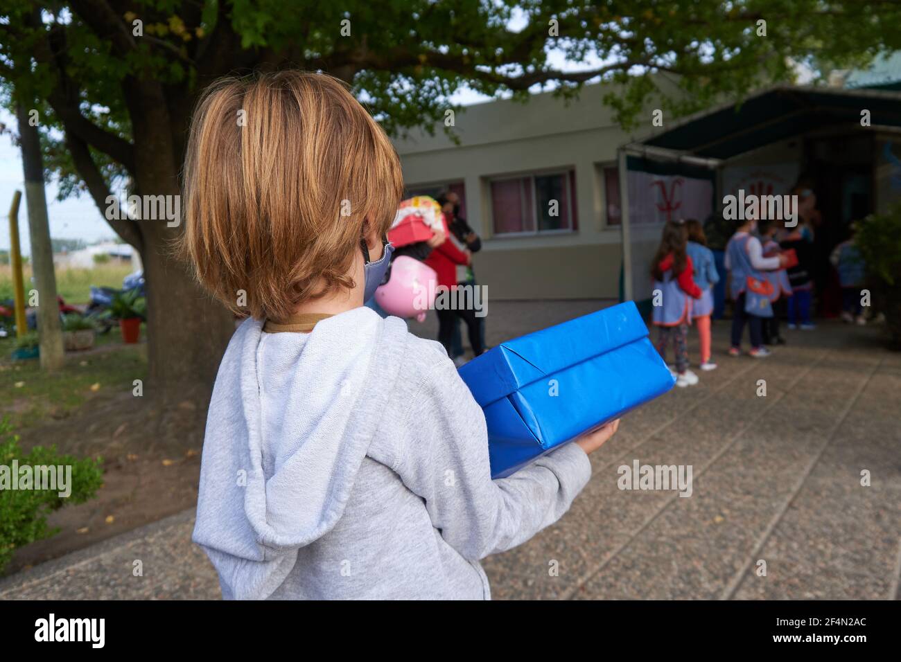 Un enfant d'âge préscolaire regarde ses collègues pendant qu'ils font la queue pour se laver les mains et faire mesurer leur température avant d'entrer dans les salles de classe.après une année d'école en ligne ou aucune école du tout en raison de la pandémie du coronavirus, les enfants d'âge préscolaire retournent à l'école en Argentine. Banque D'Images