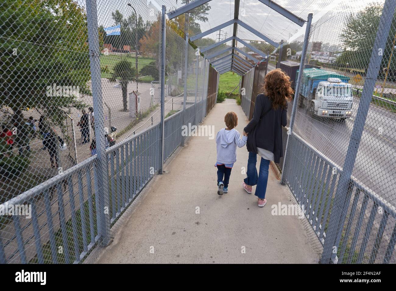 Une mère et un enfant traversent un pont piétonnier sur une route nationale tout en allant à l'école.après une année d'école en ligne ou aucune école du tout en raison de la pandémie du coronavirus, les enfants d'âge préscolaire retournent à l'école en Argentine. Banque D'Images