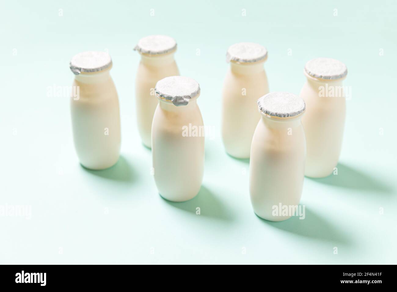 Petits flacons avec probiotiques et prébiotiques boisson laitière sur fond bleu. Production avec des additifs biologiquement actifs. Fermentation et régime guérir Banque D'Images