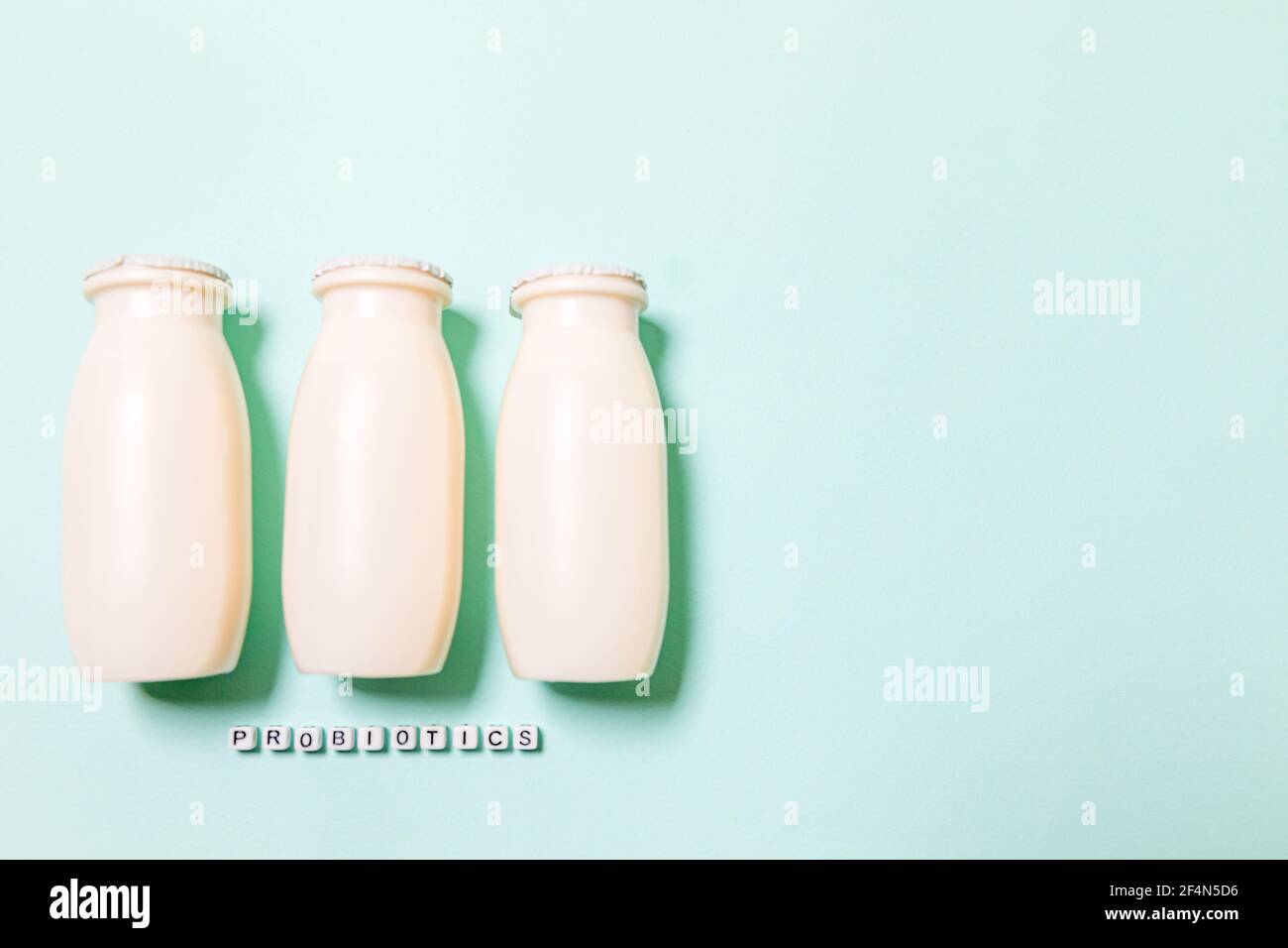 Petits flacons avec probiotiques et prébiotiques boisson laitière sur fond bleu. Production avec des additifs biologiquement actifs. Fermentation et régime guérir Banque D'Images