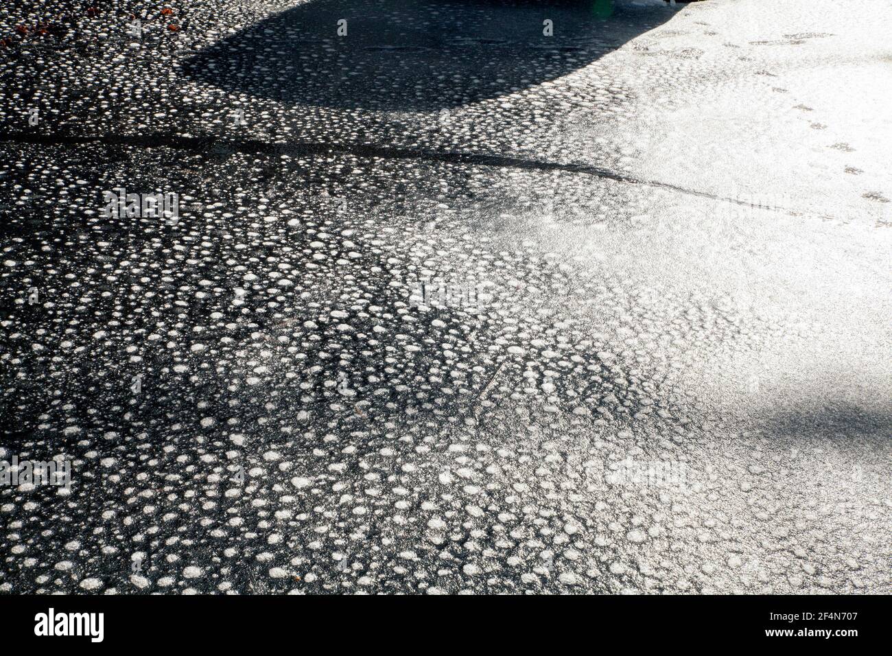 Points étranges sur une feuille de glace sur l'asphalte. Banque D'Images