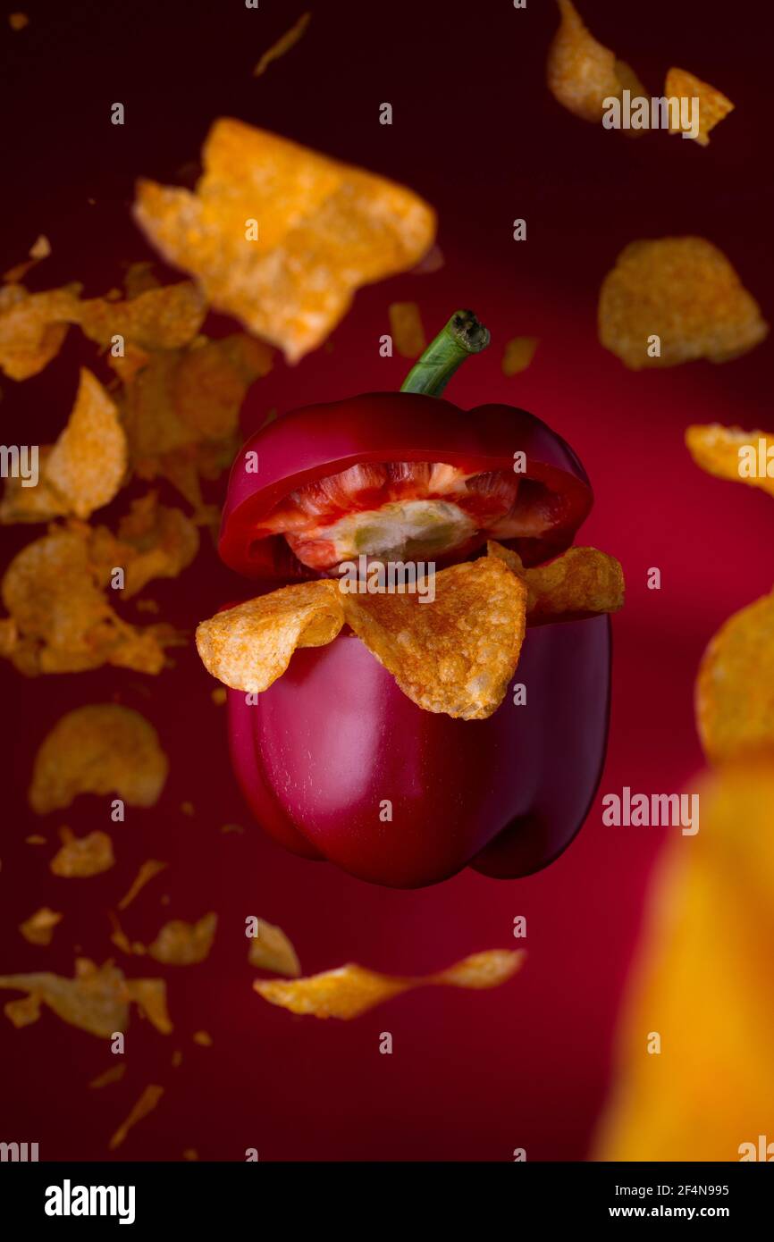 Concept de cuisine art d'un poivre volant avec des chips. Levant le poivre avec de la malbouffe savoureuse. Banque D'Images