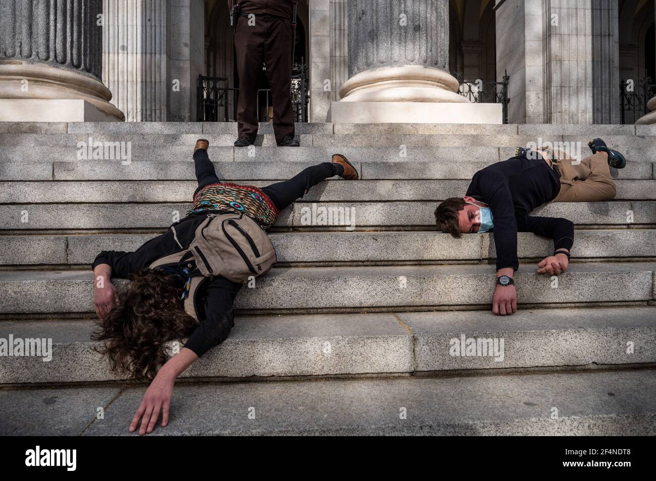 Madrid, Espagne. 22 mars 2021. Des activistes environnementaux de la « rébellion de l'extinction » (XR) et des groupes « amis de la Terre » se sont mis sur le sol pour mener une action devant le bâtiment de la Bourse de Madrid, coïncidant avec la Journée mondiale de l'eau, dénonçant le danger de la spéculation avec un bien de base comme l'eau. Les activistes ont mis en garde contre le précédent du prix de l'eau en Californie sur le marché des marchés à terme de Wall Street depuis décembre dernier. Credit: Marcos del Mazo/Alay Live News Banque D'Images