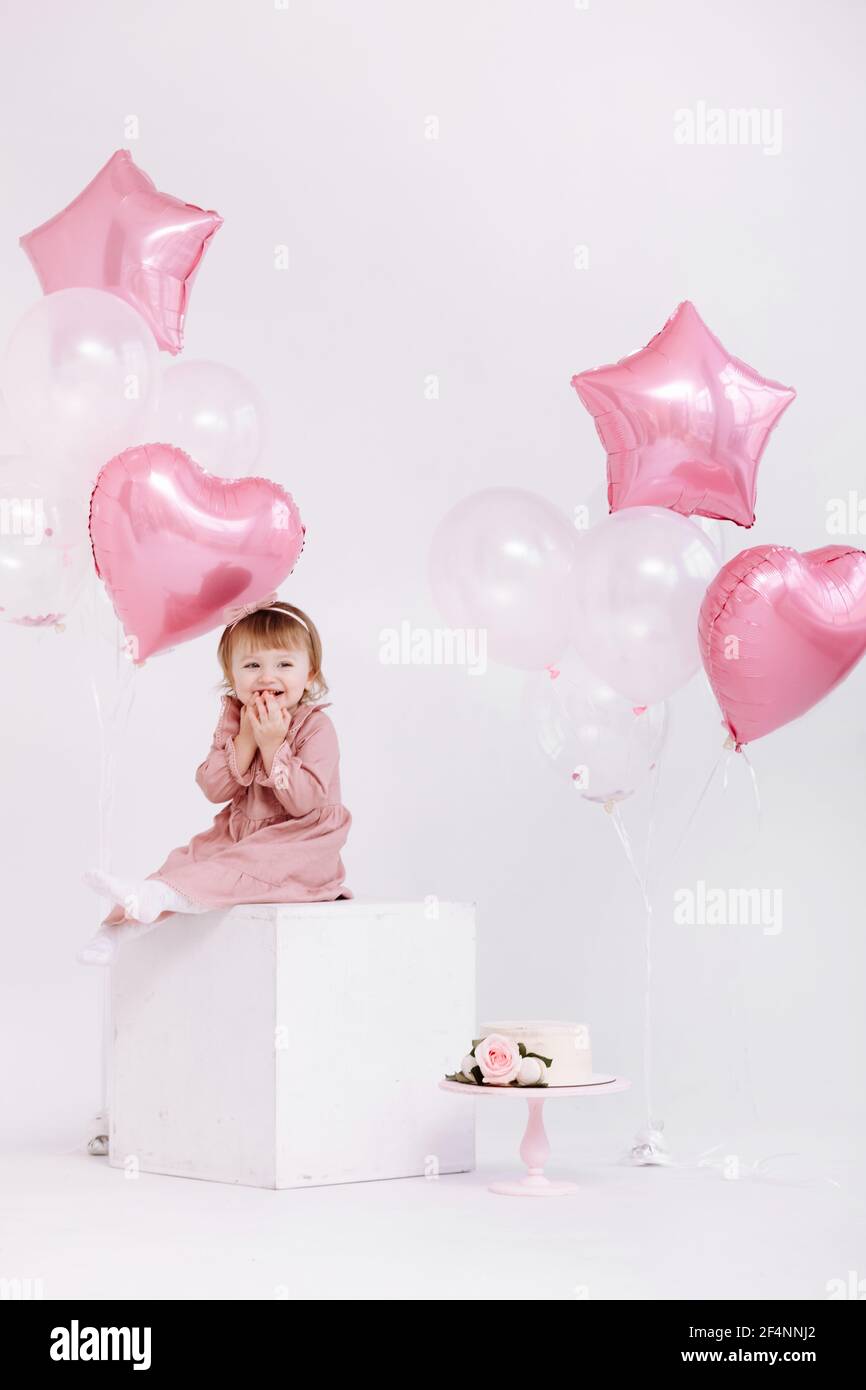 Joyeux Anniversaire 2 Ans Petite Fille En Robe Rose Gateau Blanc Avec Bougies Et Roses Decorations D Anniversaire Avec Ballons Blancs Et Roses Et Photo Stock Alamy