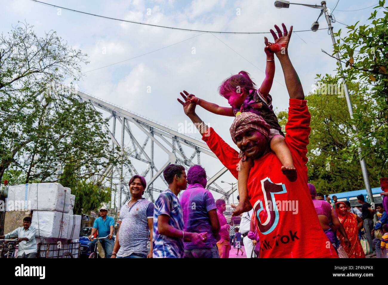 Un père danse avec sa fille sur ses épaules lors d'un festival Holi à Kolkata, en Inde. Banque D'Images