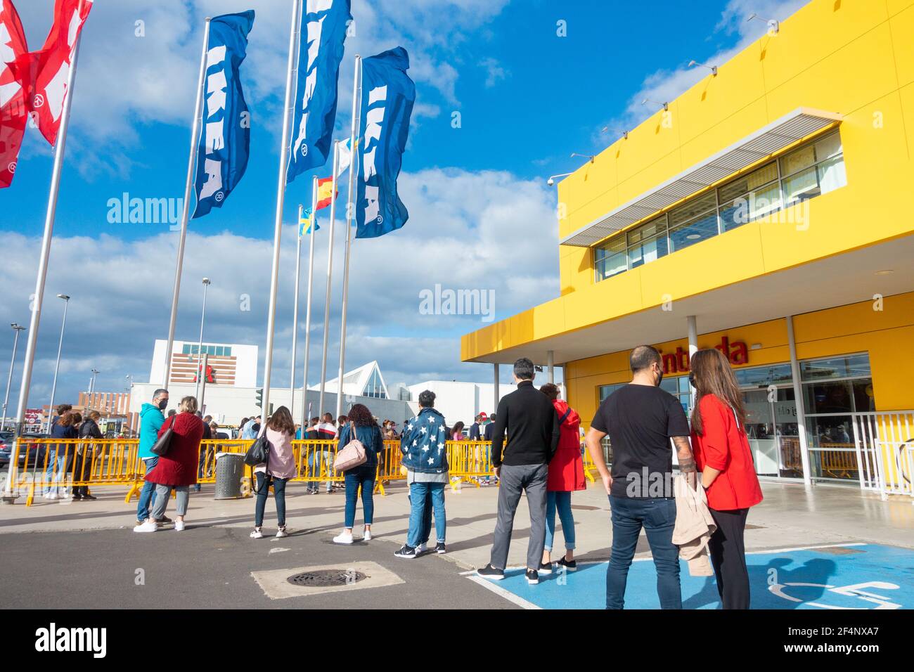 Des personnes portant des masques, des couvertures font la queue à l'extérieur du magasin Ikea en Espagne pendant la pandémie de coronavirus de Covid. Banque D'Images