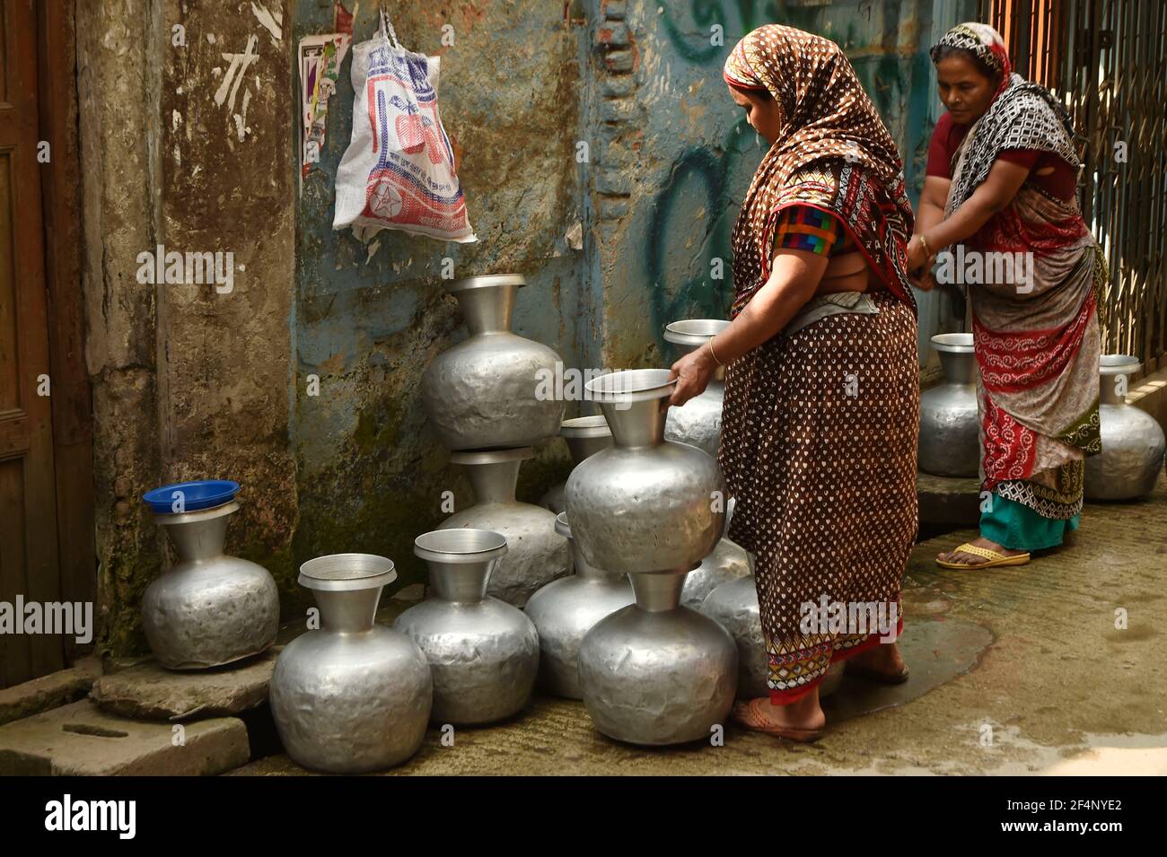 Dhaka. 22 mars 2021. Le 22 mars 2021, les femmes collectent de l'eau dans un puits tubulaire de Dhaka, au Bangladesh. La pénurie d'eau est un problème dans certaines parties de Dhaka. Pour les habitants des taudis ici, la pénurie d'eau continue d'être l'une des principales préoccupations chaque année. Credit: Xinhua/Alay Live News Banque D'Images