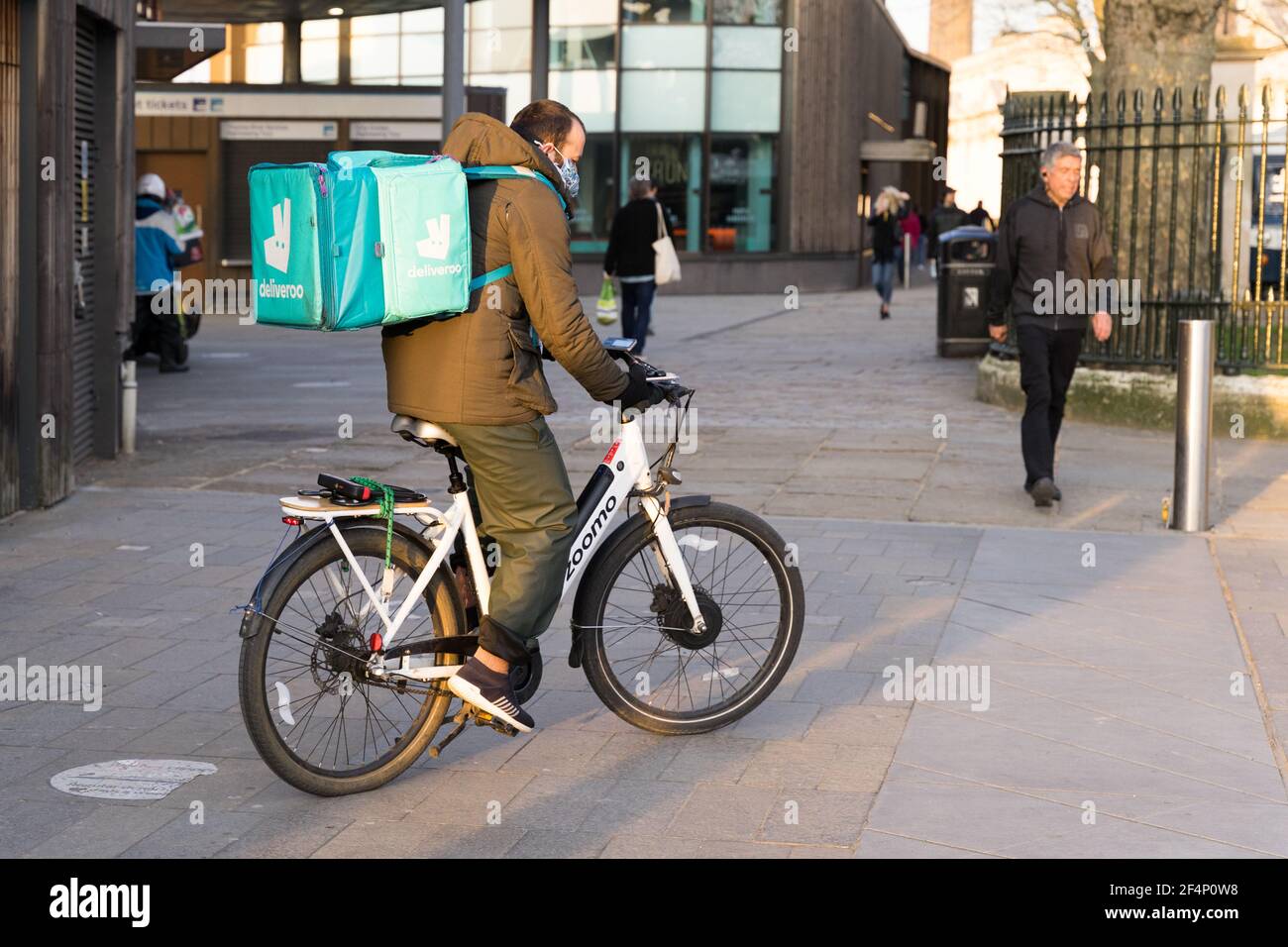 Deliveroo homme sur son vélo de coursier sur son chemin à Client à emporter, Londres Greenwich, Angleterre Banque D'Images