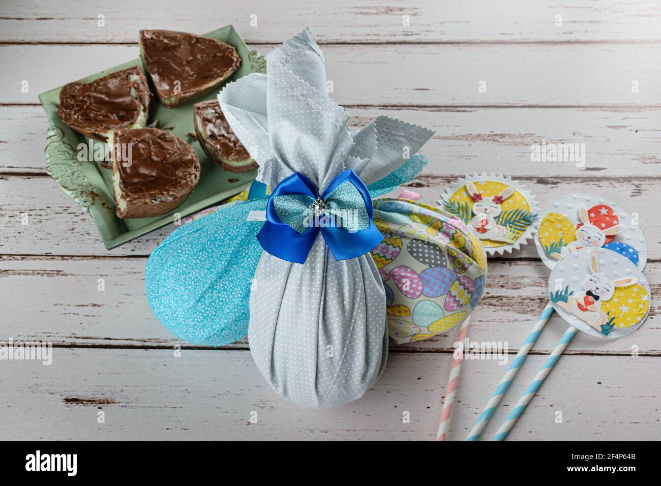 Œufs de Pâques au chocolat emballés avec des tissus colorés. À côté de l'oeuf de Pâques farci de brigadeiro blanc (brigadier). Banque D'Images