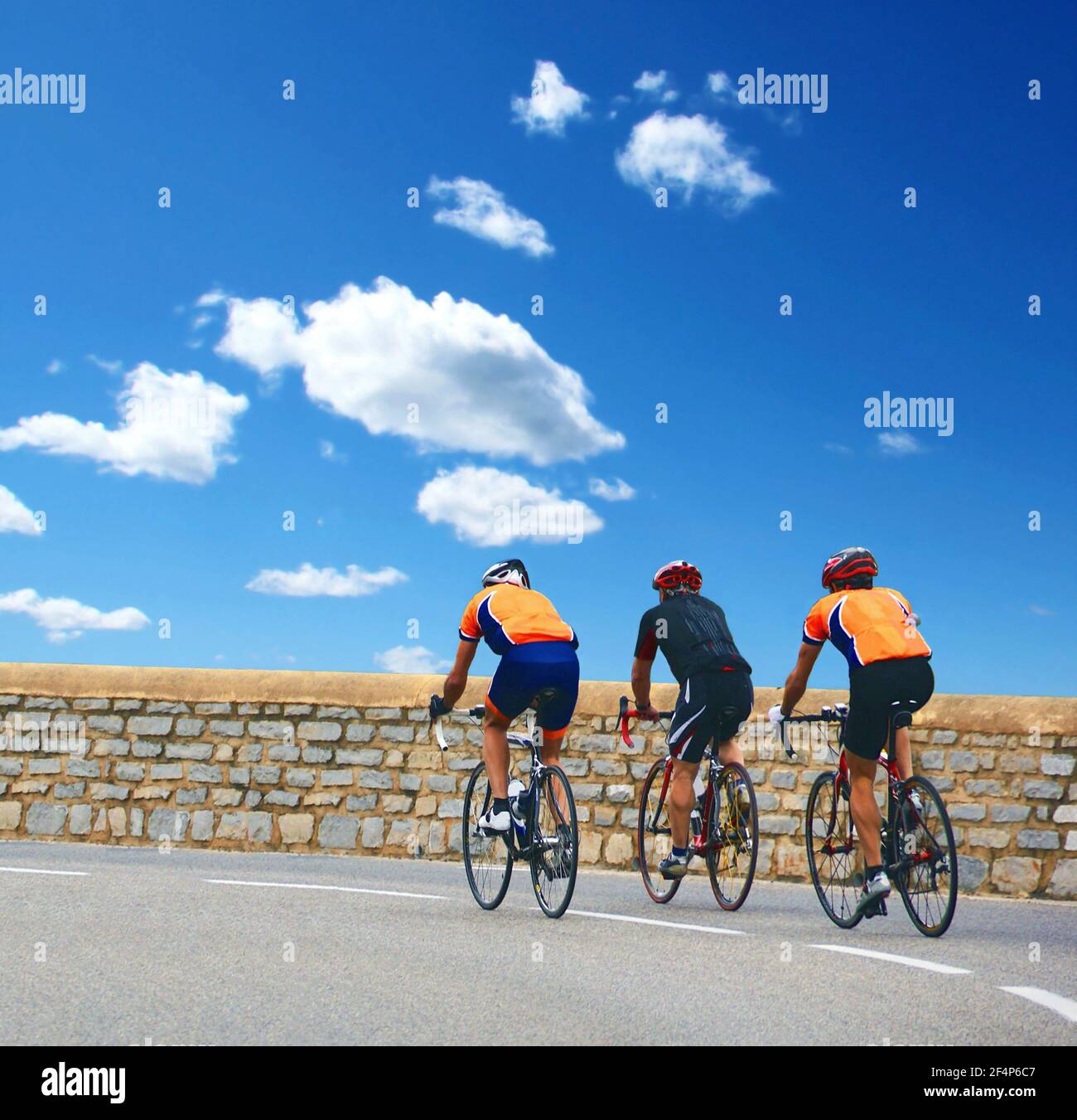 Cycliste sur une route de montagne sur fond de ciel bleu. Banque D'Images
