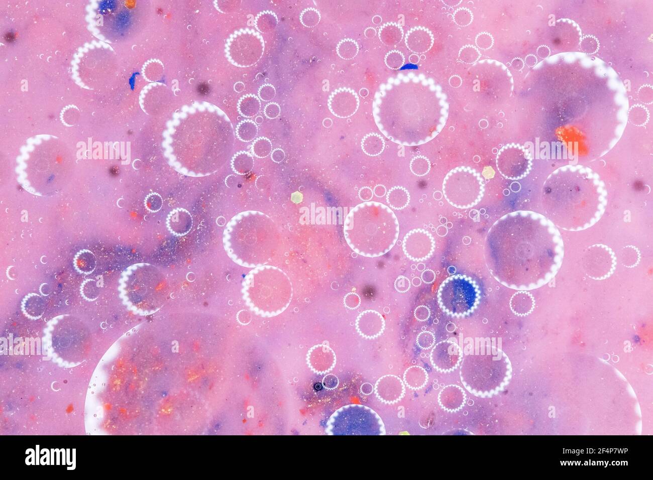 Arrière-plan abstrait rose, cercles de lumière sur l'eau. Couleurs pastel fraîches. Arrière-plan flou. Macro Banque D'Images