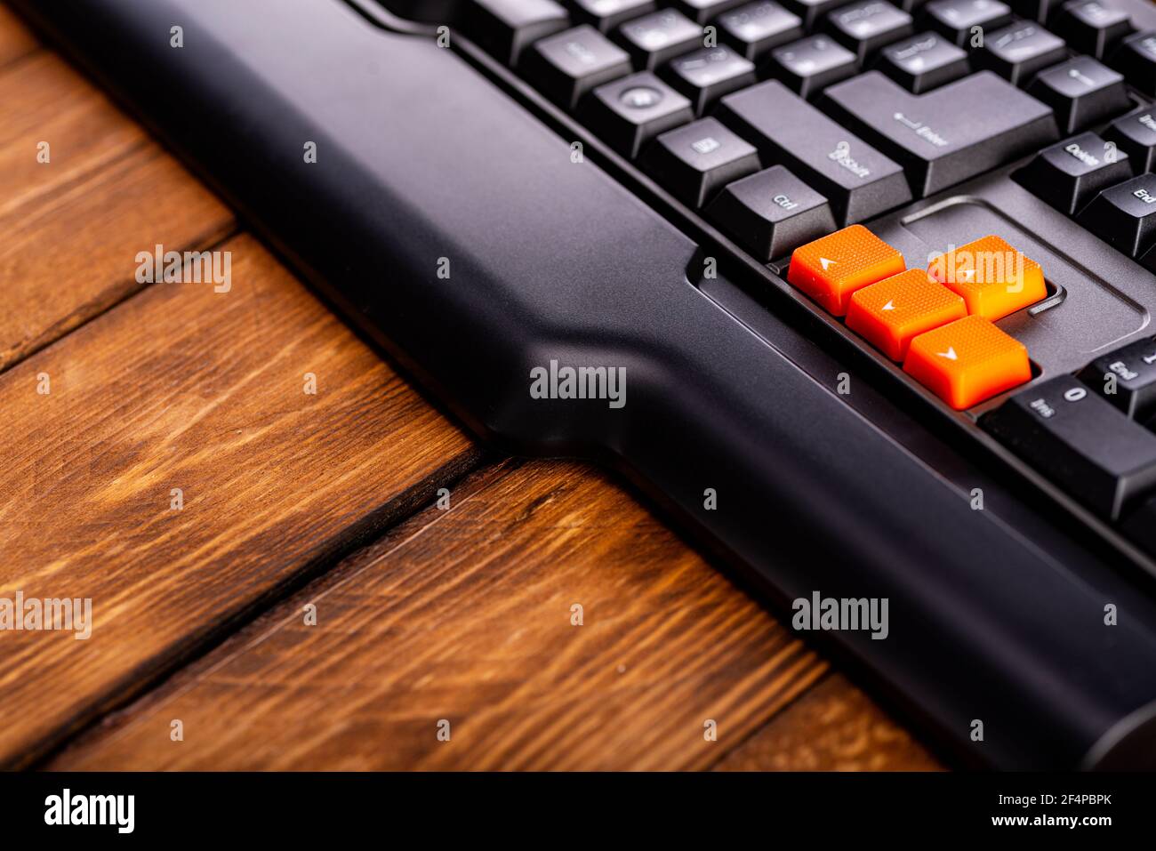 Touches fléchées orange sur un clavier noir, touches haut, bas, gauche, droite sur un clavier d'ordinateur de jeu. Banque D'Images