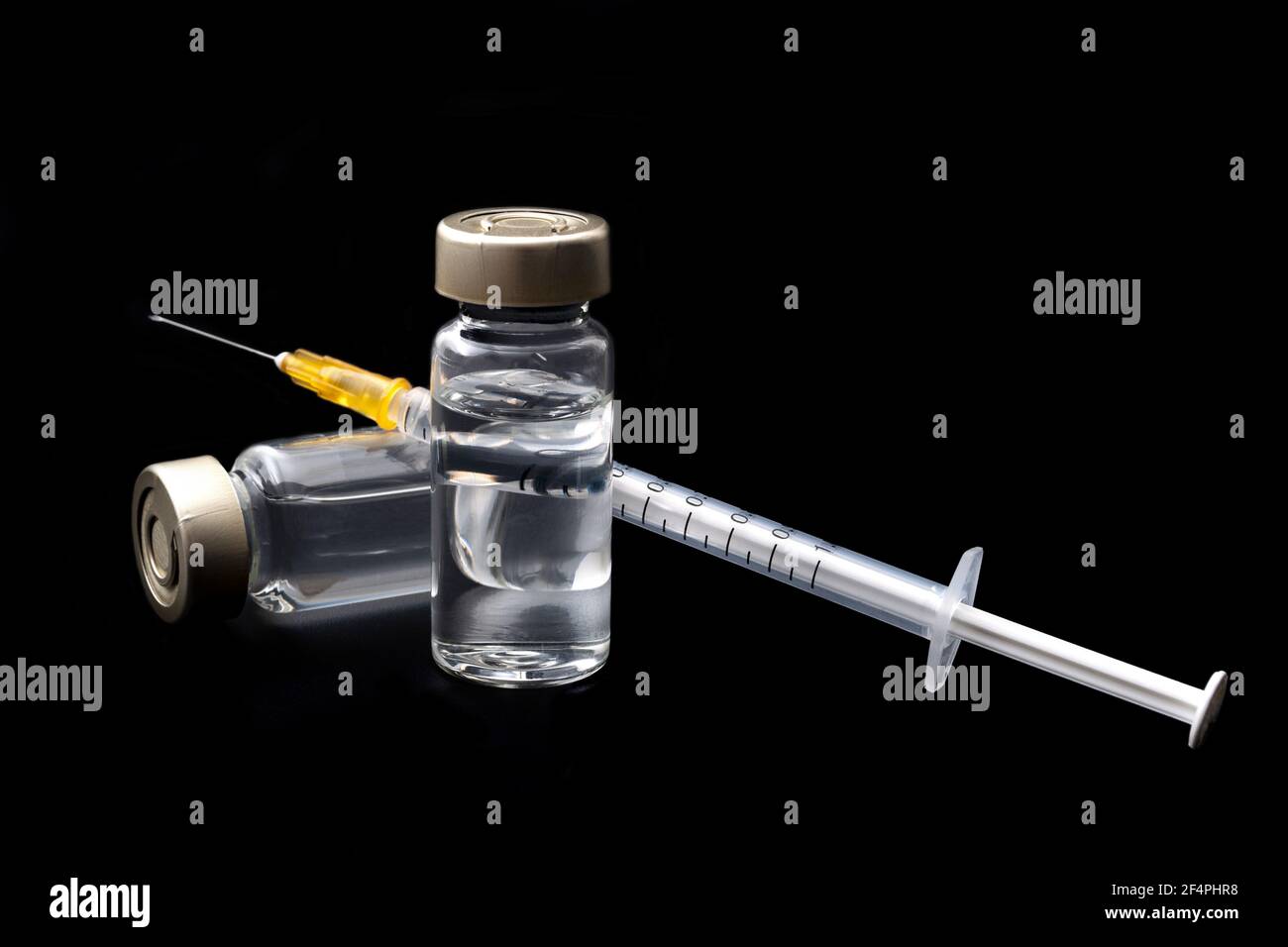 Vaccins, toxine botulinique et ampoules d'insuline concept thème avec des flacons en verre avec liquide clair à côté d'une seringue et une aiguille hypodermique isolée sur b Banque D'Images
