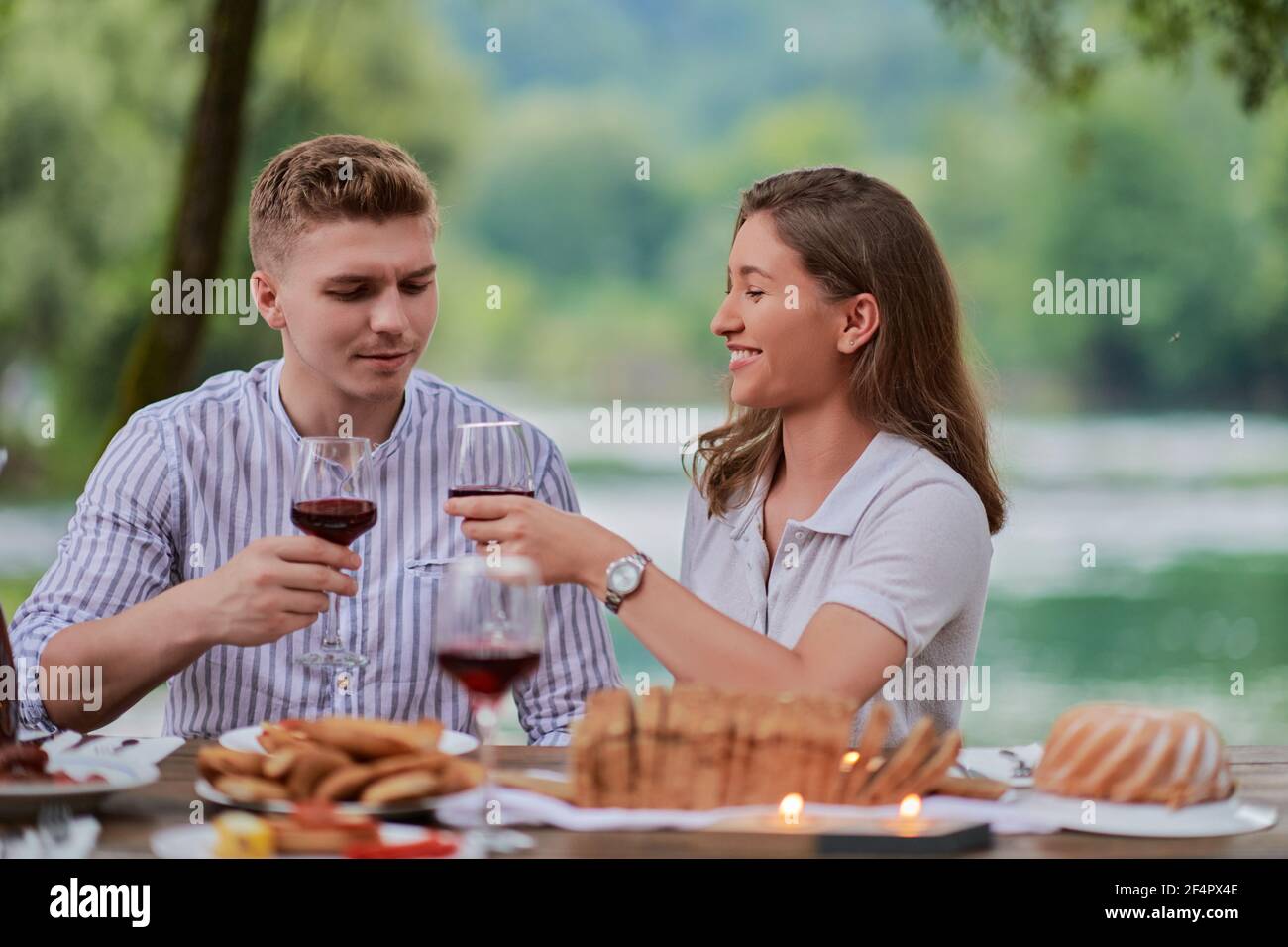 couple toaster un verre de vin rouge tout en dégustant un pique-nique  français faites la fête en plein air Photo Stock - Alamy